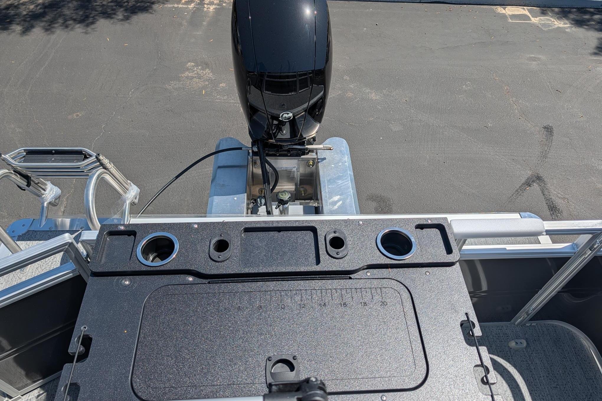 2026 Sun Tracker Fishin' Barge 22 DLX boat with motor and fishing station.