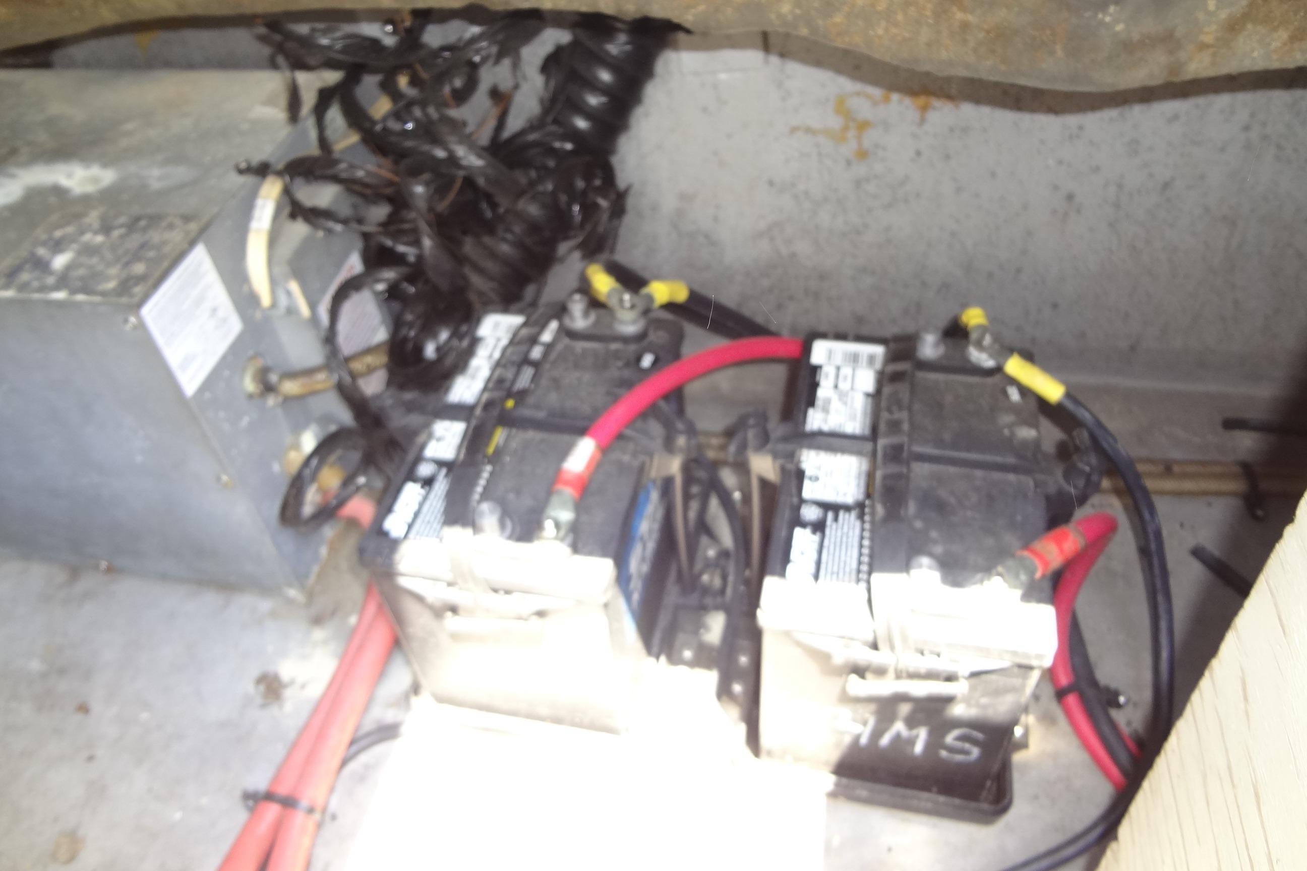 Battery compartment of a 2000 Chaparral Signature 260 boat with wiring and connections.