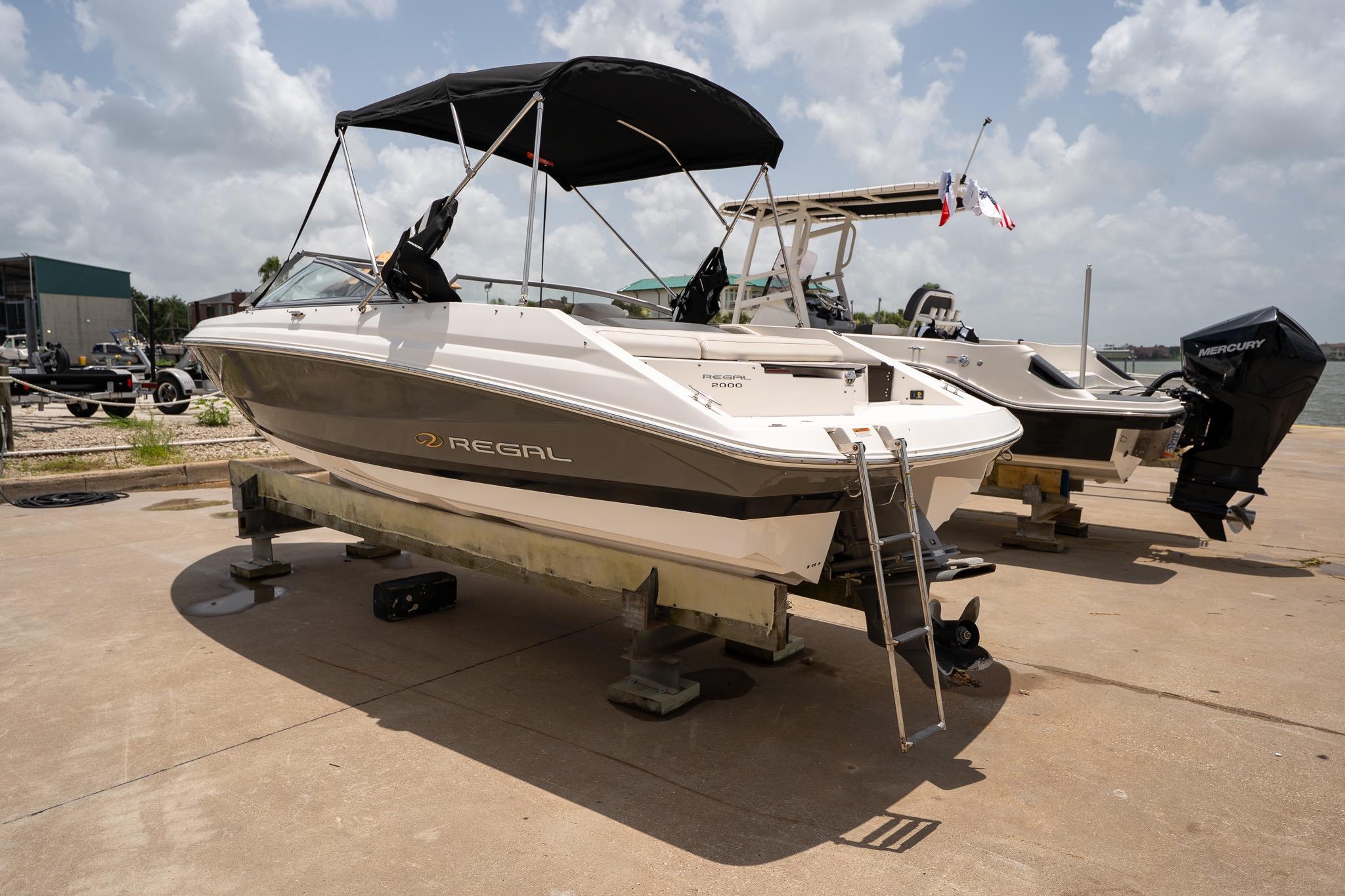 2008 Regal 2000 Bowrider boat on dry dock with ladder and canopy.