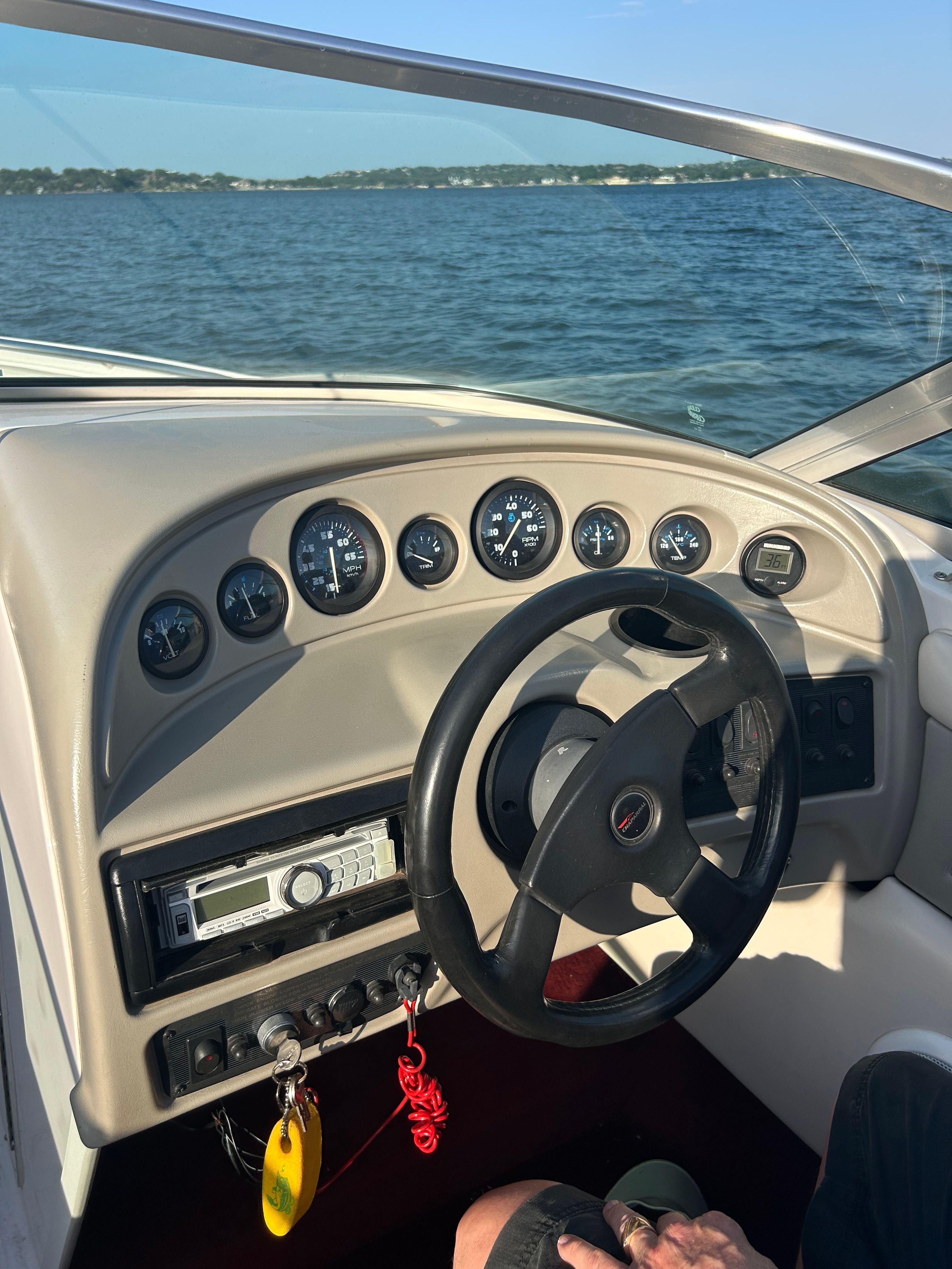 The image shows the cockpit of a 1995 Chaparral 2330 boat on the water.