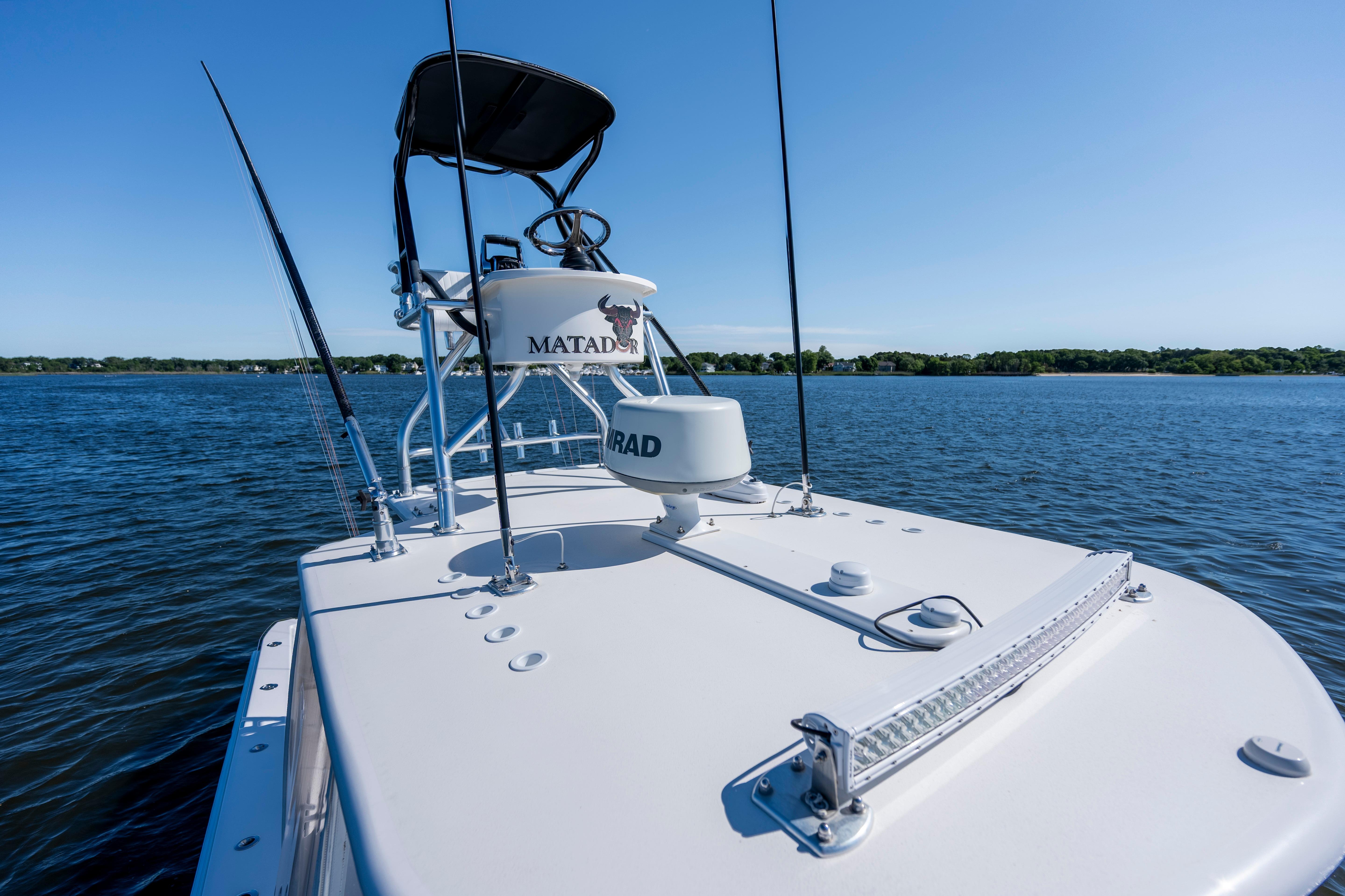 2015 Contender 39 ST boat on calm water under clear blue sky.