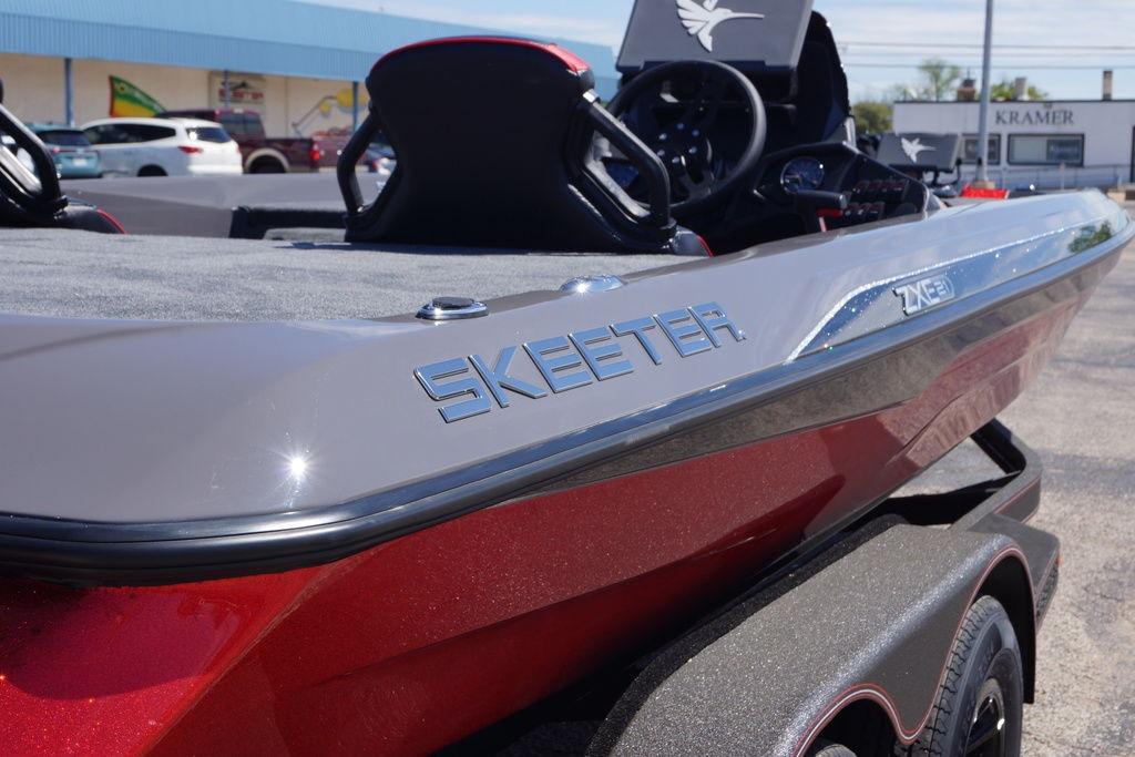 2026 Skeeter ZXE21 boat, sleek design, red and gray finish, parked outdoors.