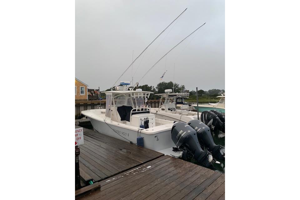 2017 Regulator 31 boat docked with dual outboard engines, overcast sky.