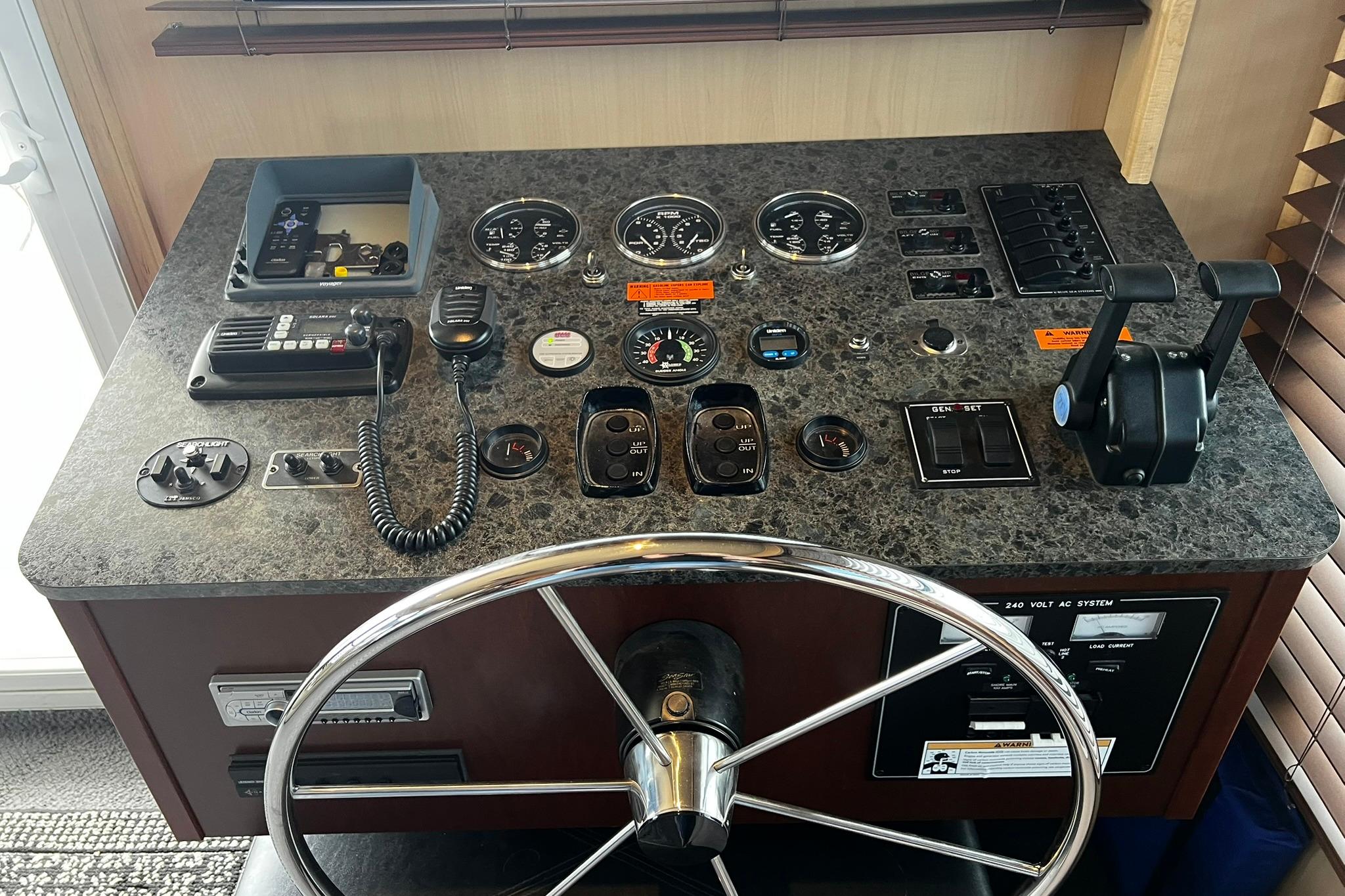 Control panel of a 2010 Skipperliner 480 Flybridge with steering wheel and navigation instruments.