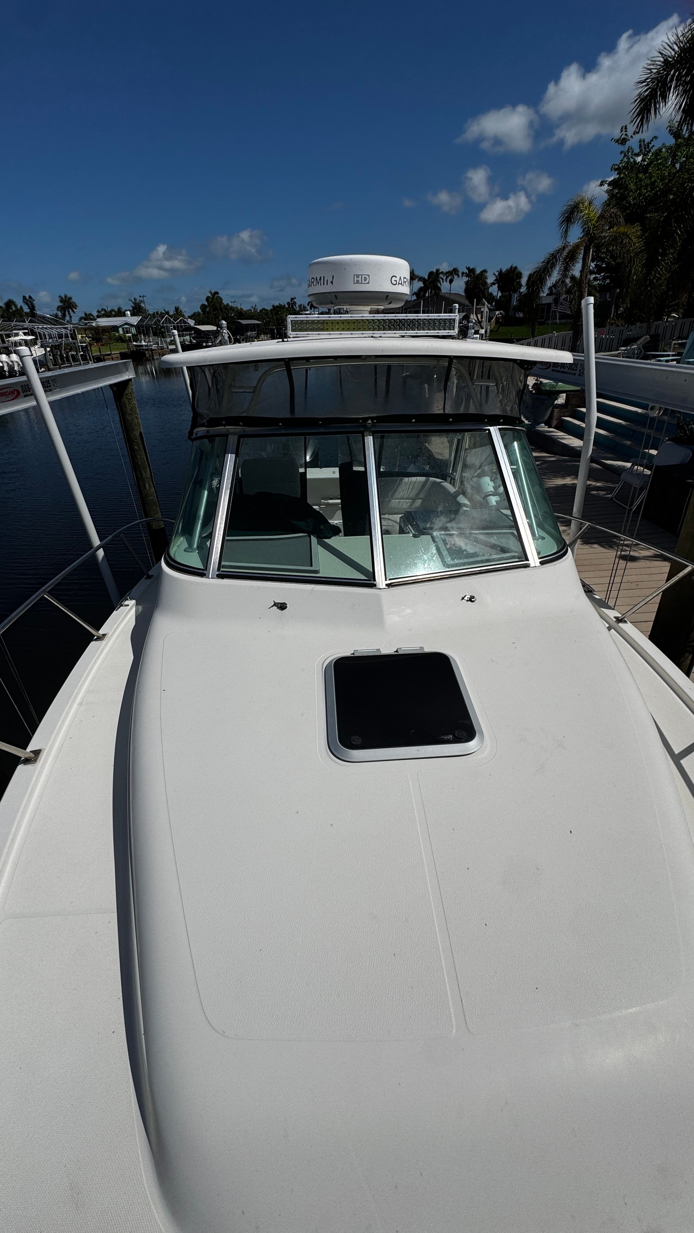 2003 Pursuit 3070 at the dock with clear skies and water in the background.