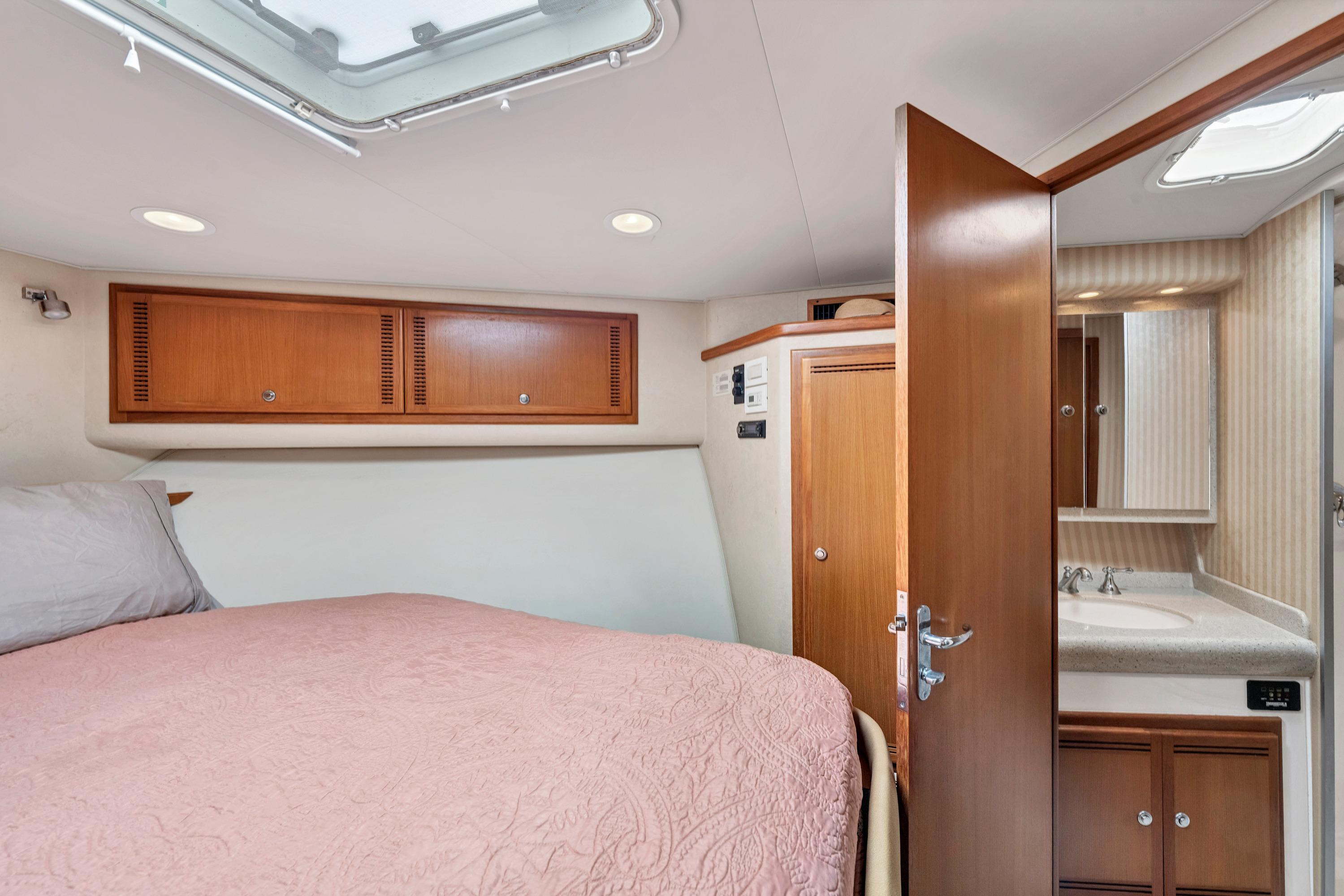 2010 Cabo 45 Express cabin interior with bed, wooden cabinets, and bathroom.