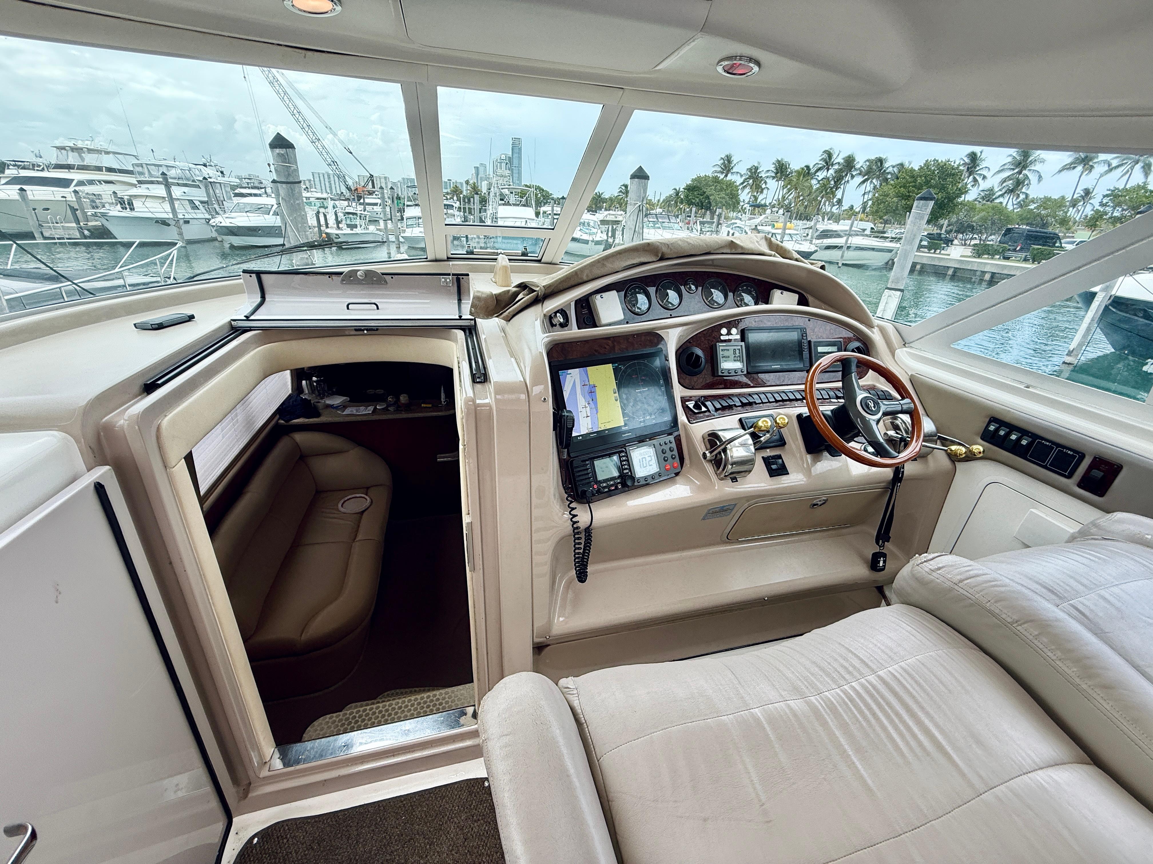 Interior view of 2003 Sea Ray 480 Motor Yacht helm with navigation equipment and seating.