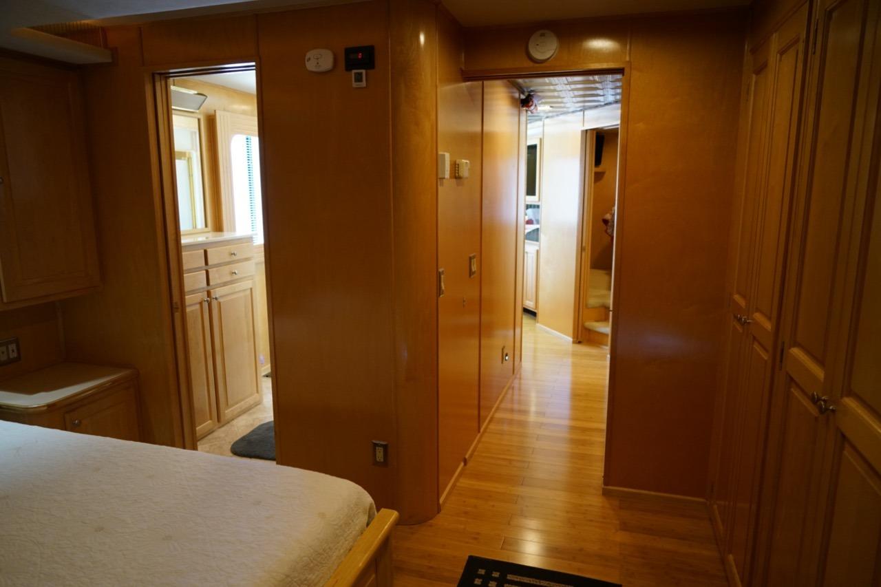 Interior of 2000 Stardust Cruisers houseboat, featuring wooden cabinetry and hallway view.