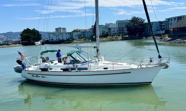 Beneteau Oceanis 40 CC sailboat from 1996 on calm water near urban buildings.
