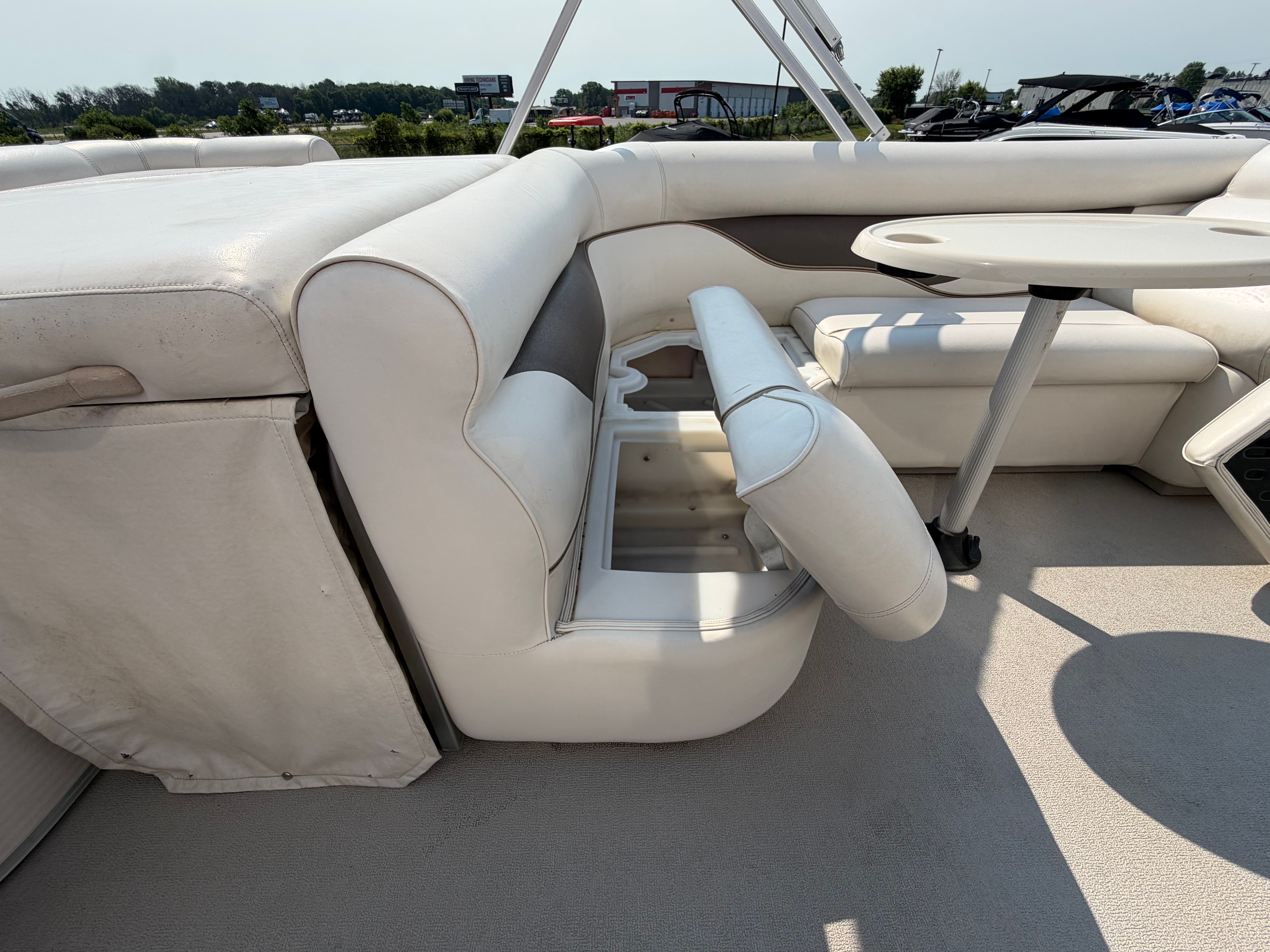 Interior of a 2007 Premier 225 Sunsation with white upholstered seating and a table.