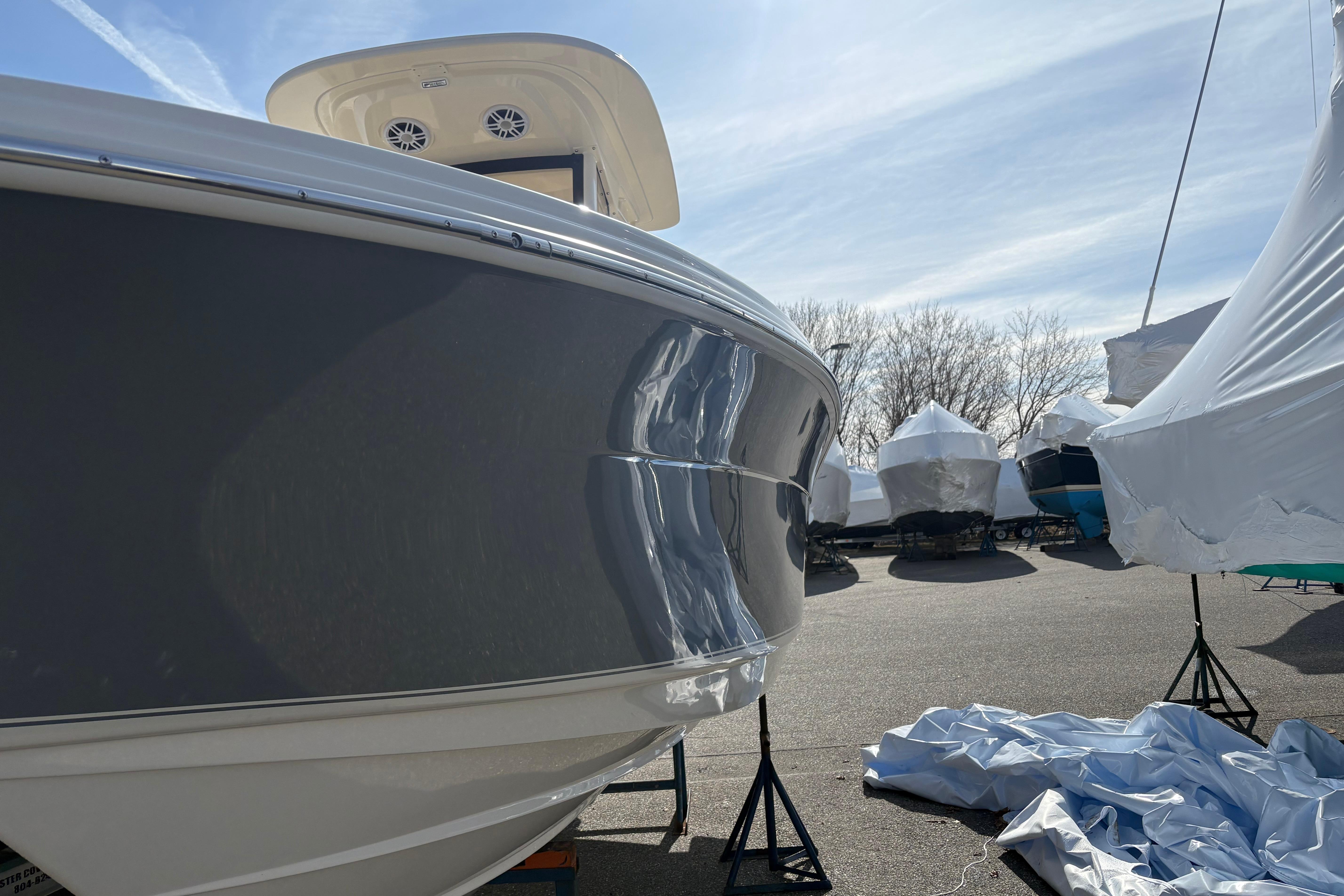 2026 Scout 220 XSF boat in storage, partially covered, under a clear sky.