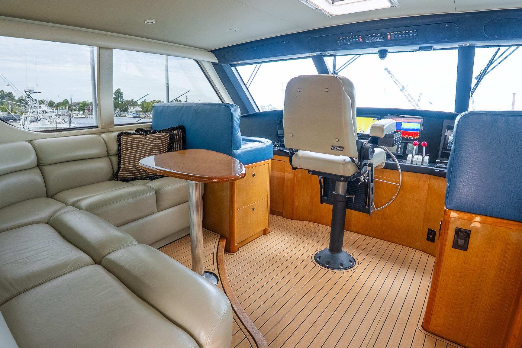 Luxurious interior of 2002 Viking 61 Enclosed Bridge yacht with leather seating and navigation controls.