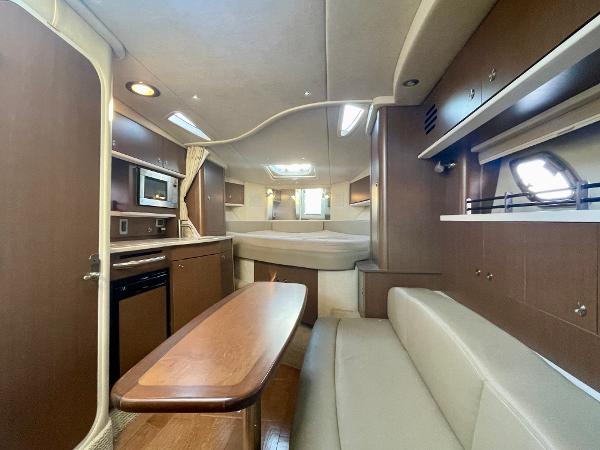 2014 Sea Ray 330 Sundancer cabin interior with kitchen, seating, and bed.