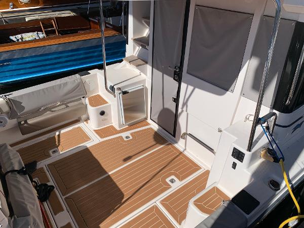 2021 Cutwater C-32 CB boat interior with wood flooring and seating area.