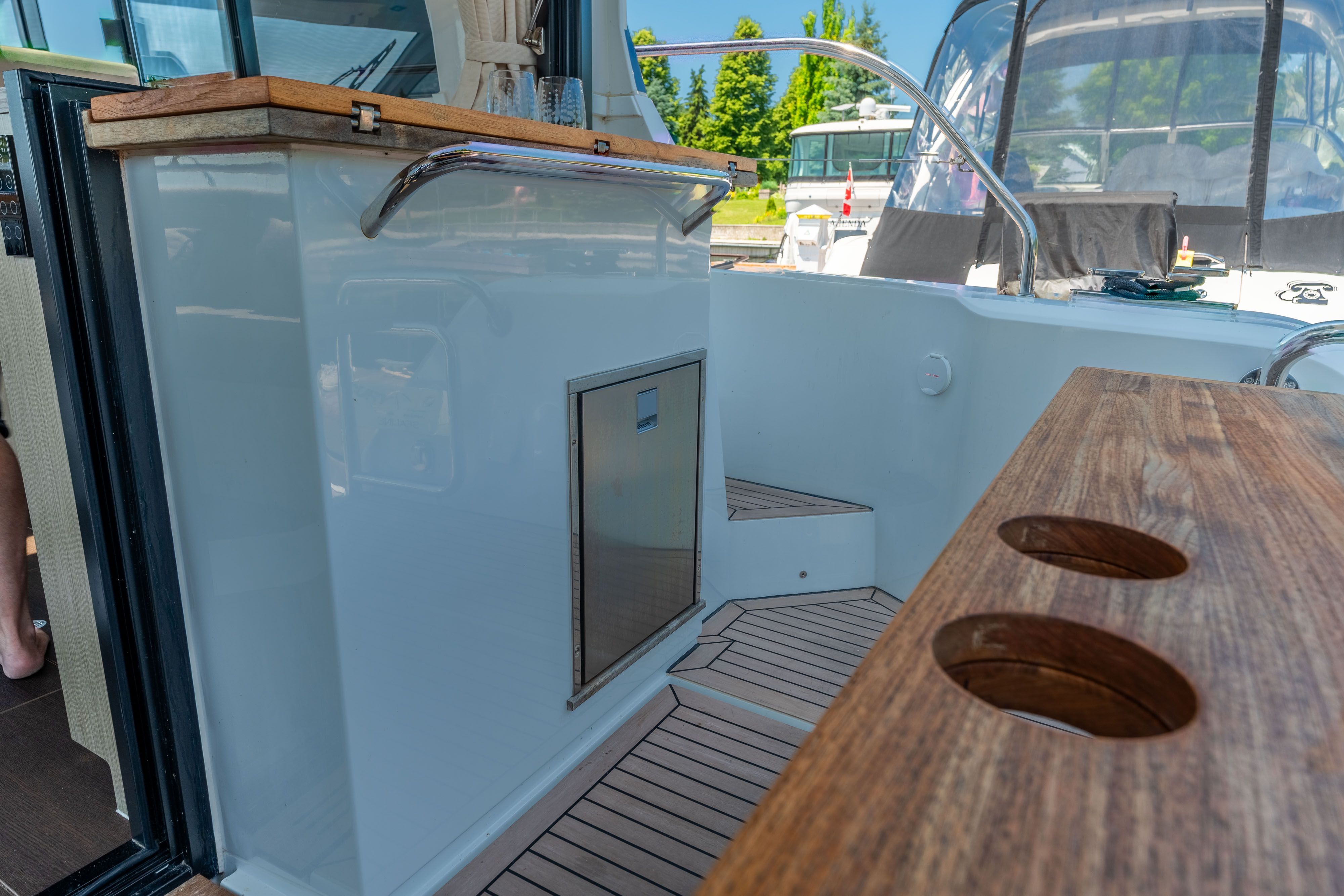 Sealine C335V 2023: Elegant cockpit with wood accents and modern amenities.