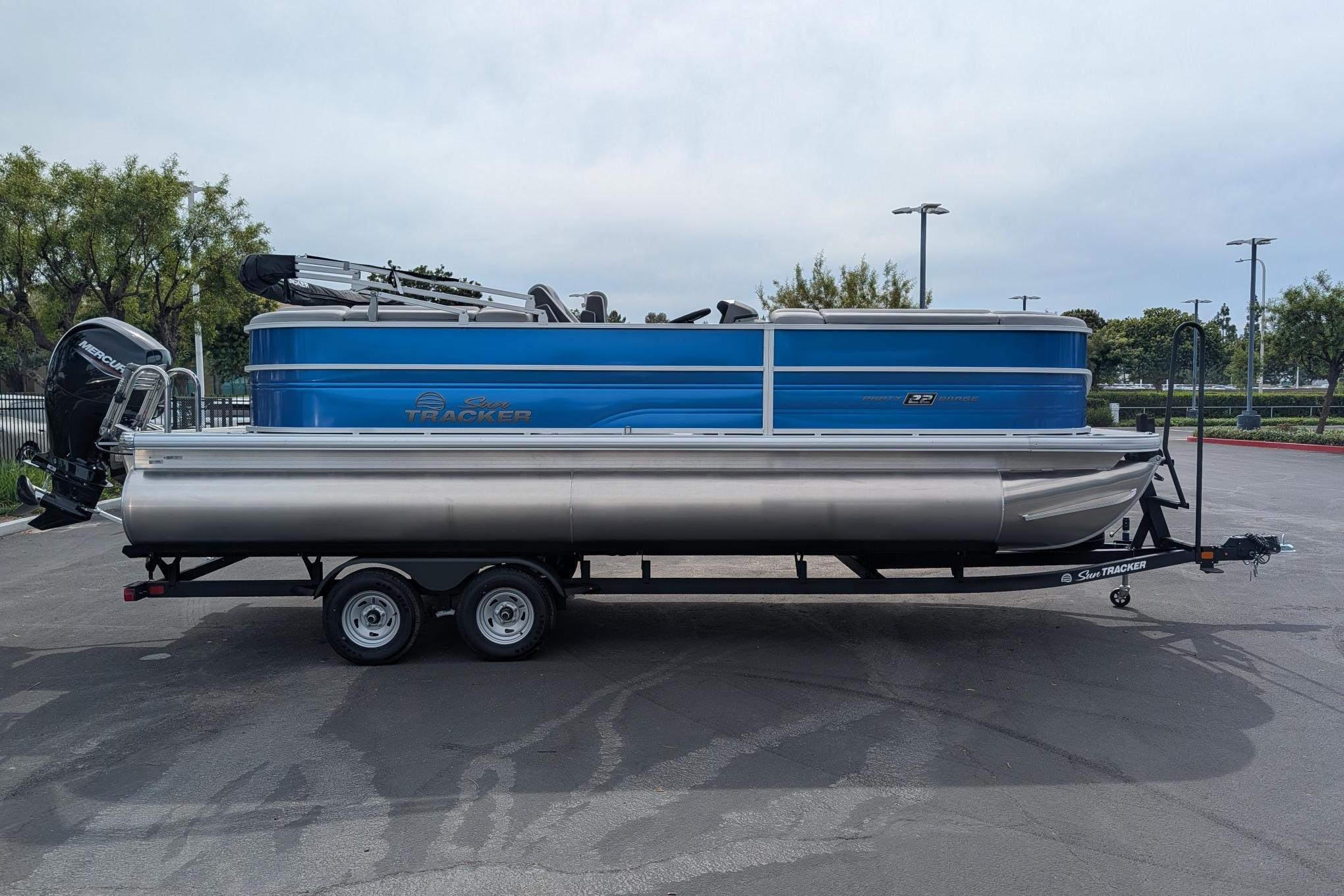 2026 Sun Tracker Party Barge 22 DLX pontoon boat on trailer, parked outdoors.