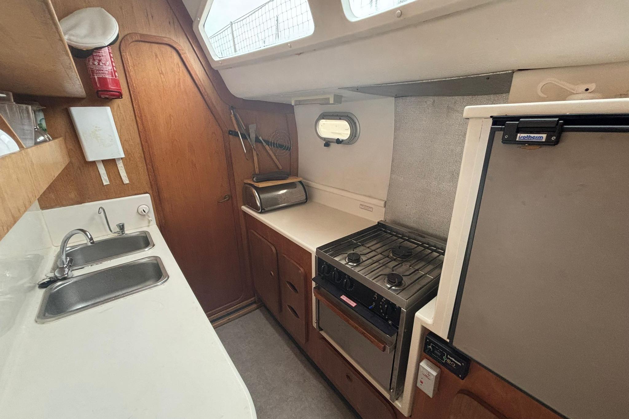 1998 Prout 38 yacht kitchen with stove, sink, and storage cabinets.