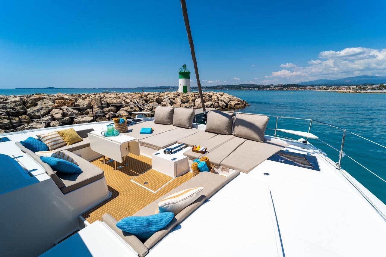 Luxurious Bali 5.4 yacht deck with seating, ocean view, and lighthouse, 2022 model.