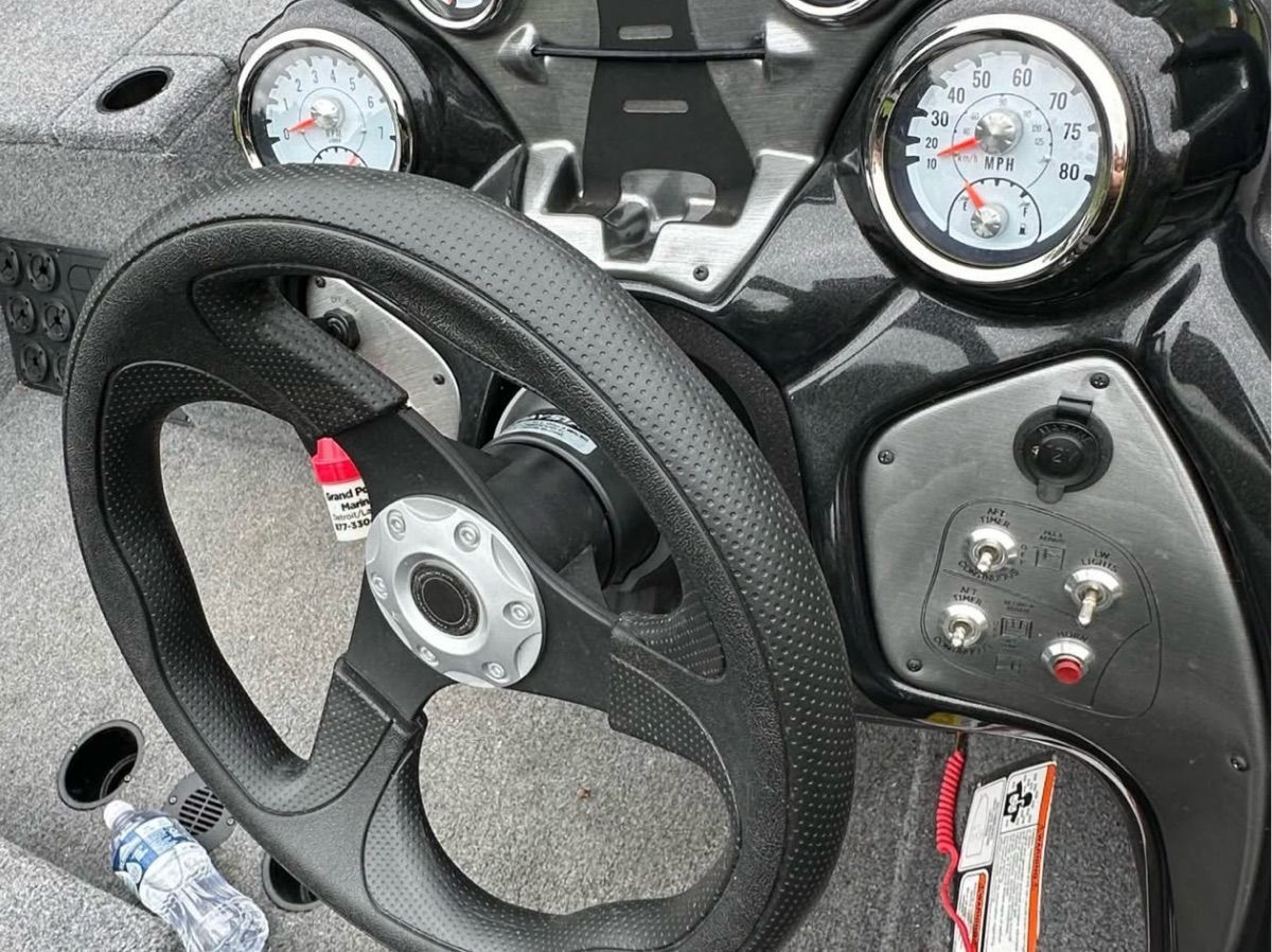 The image shows the dashboard of a 2022 Bass Tracker 195TXW with a steering wheel and gauges.