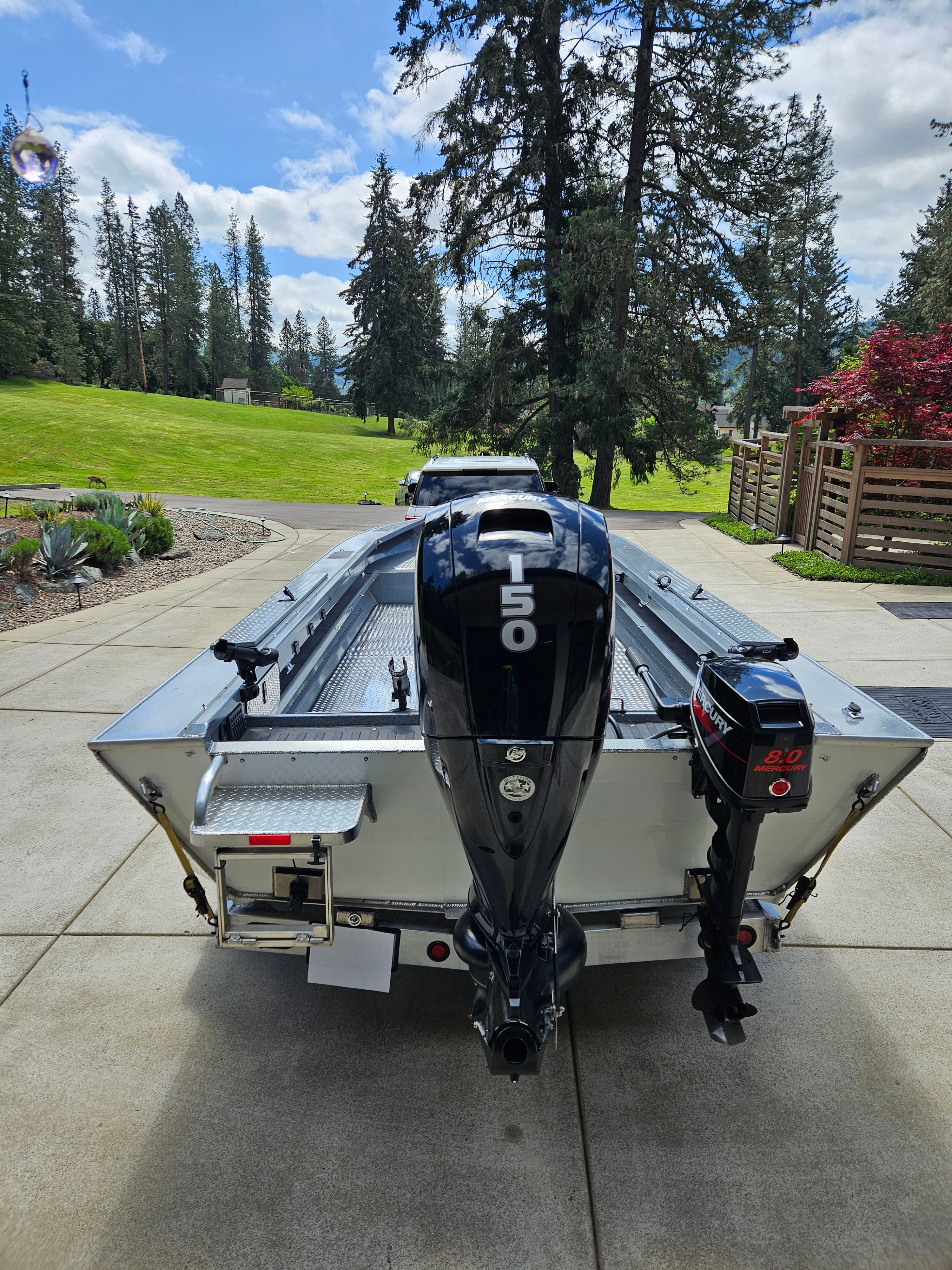 A 2023 Custom Sport Special boat with two outboard motors on a paved area.
