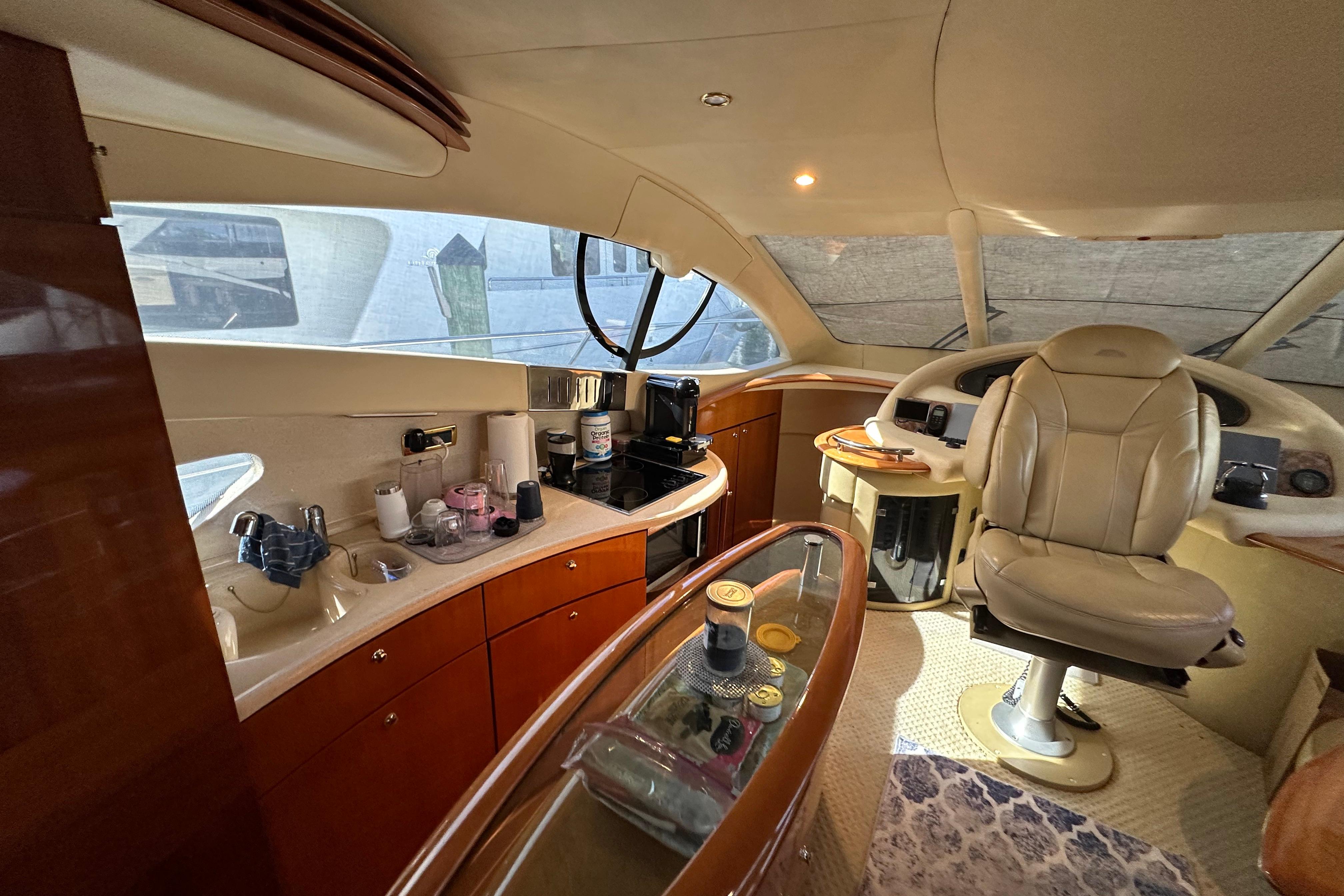 Luxurious interior of a 2004 Azimut 55E yacht with elegant helm and cabinetry.