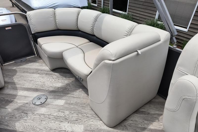 2017 Manitou 25 Oasis SE boat interior with beige seating and wood flooring.