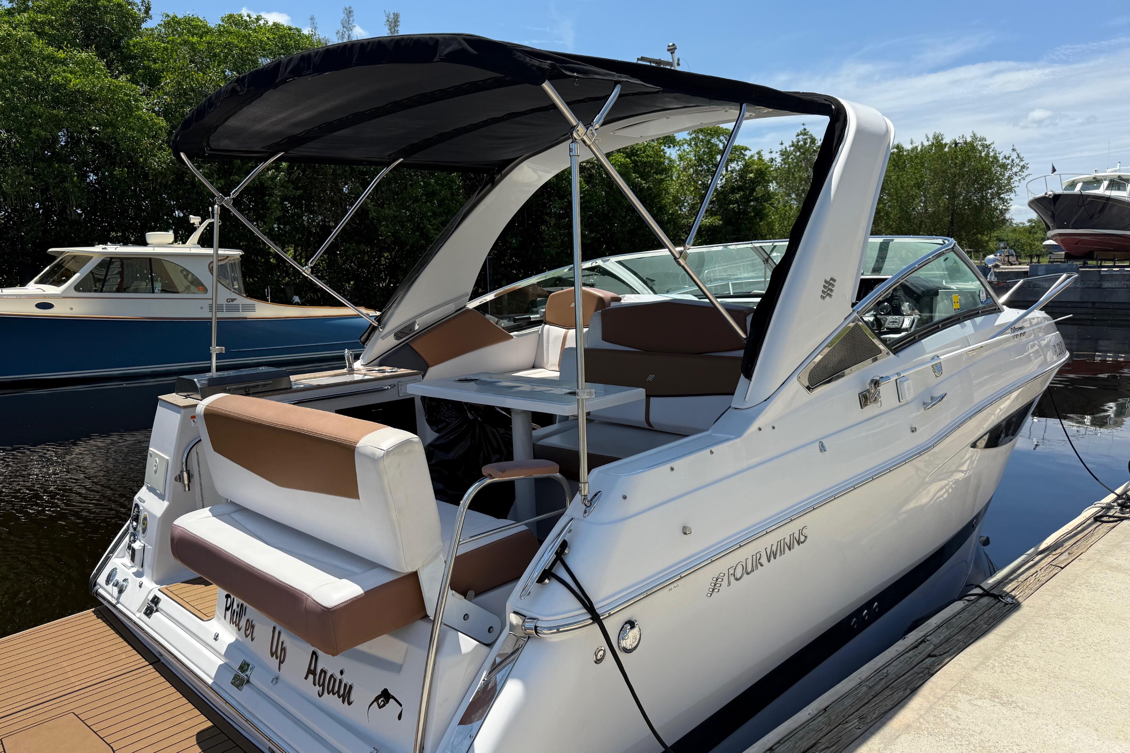 2017 Four Winns V275 boat docked, featuring sleek design and spacious seating.