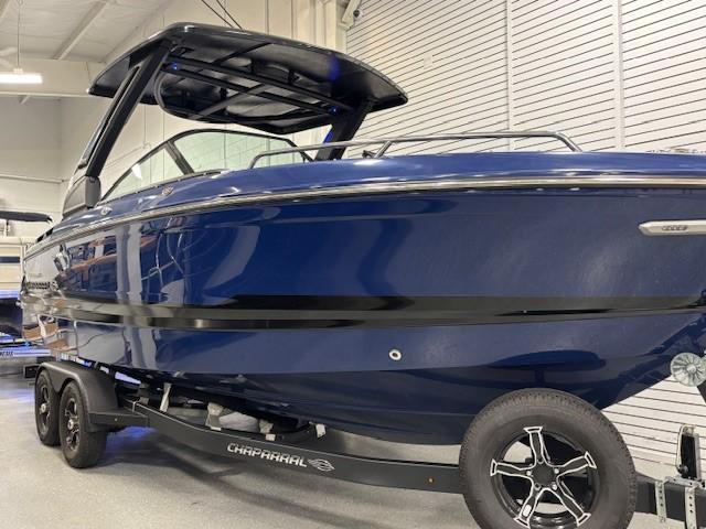 2026 Chaparral SSX 6 boat in showroom, sleek blue design on trailer.