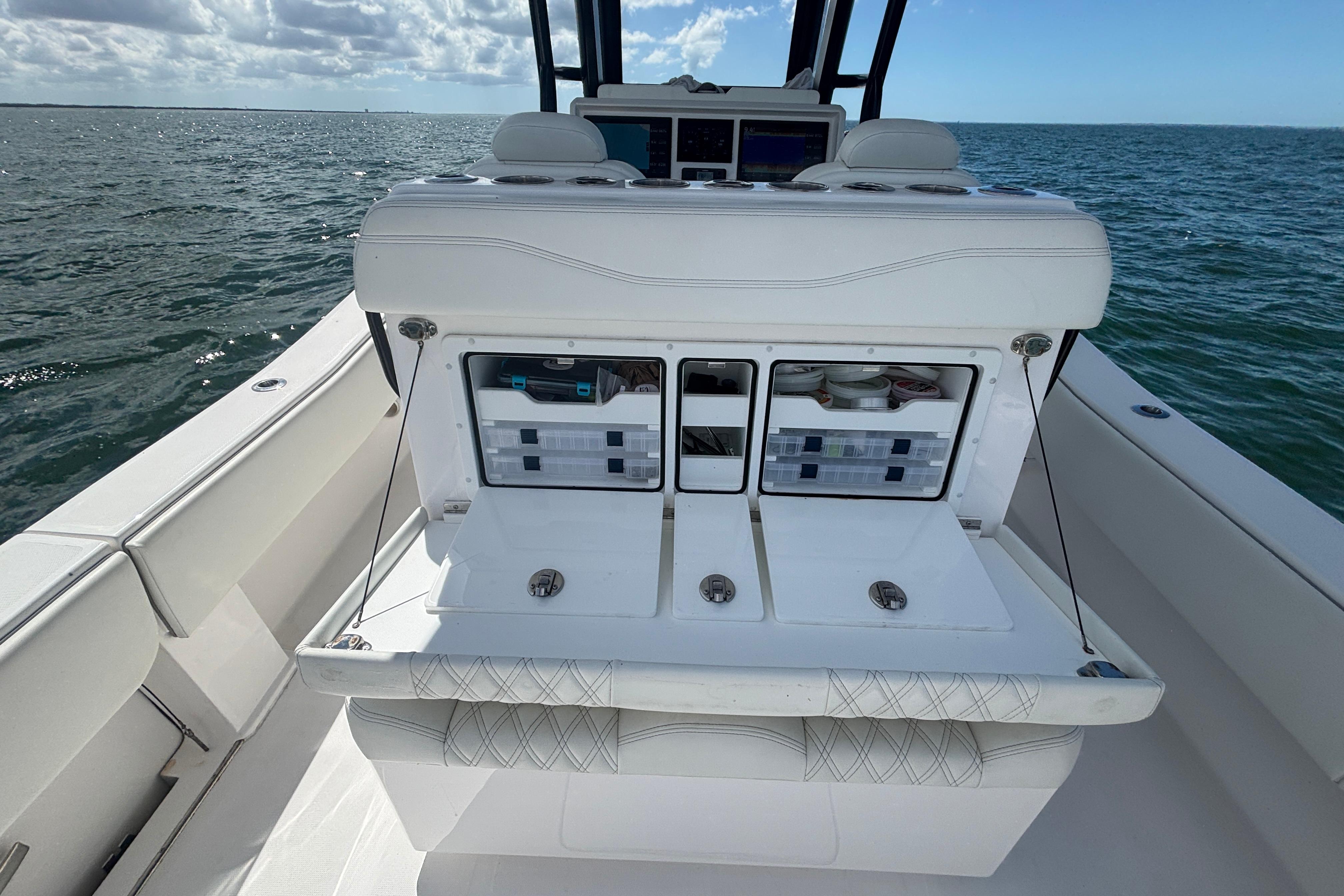 2024 Invincible 36 Open Fisherman boat with storage compartments on open sea.