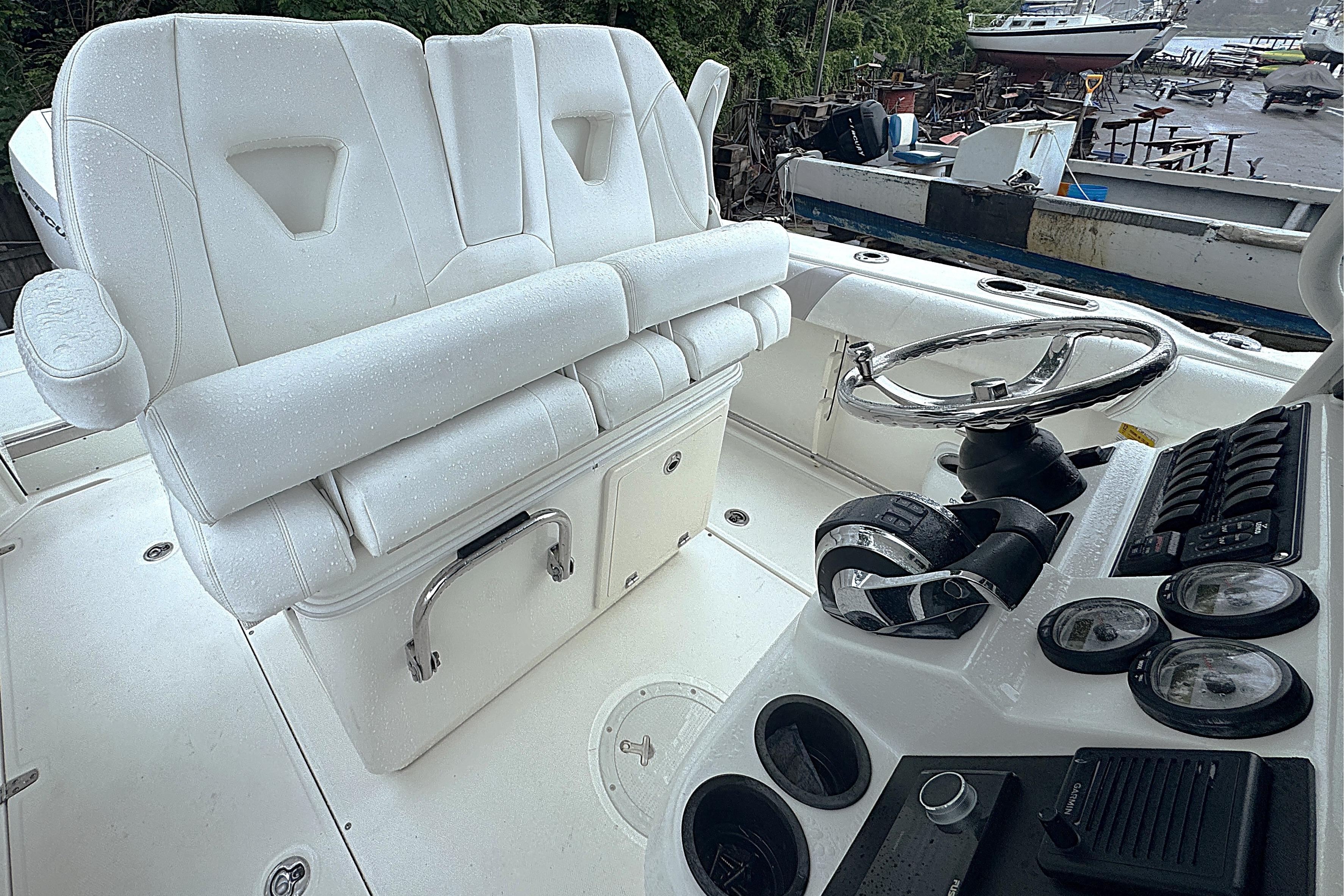 2014 Boston Whaler 250 Outrage boat interior with white seating and control panel.