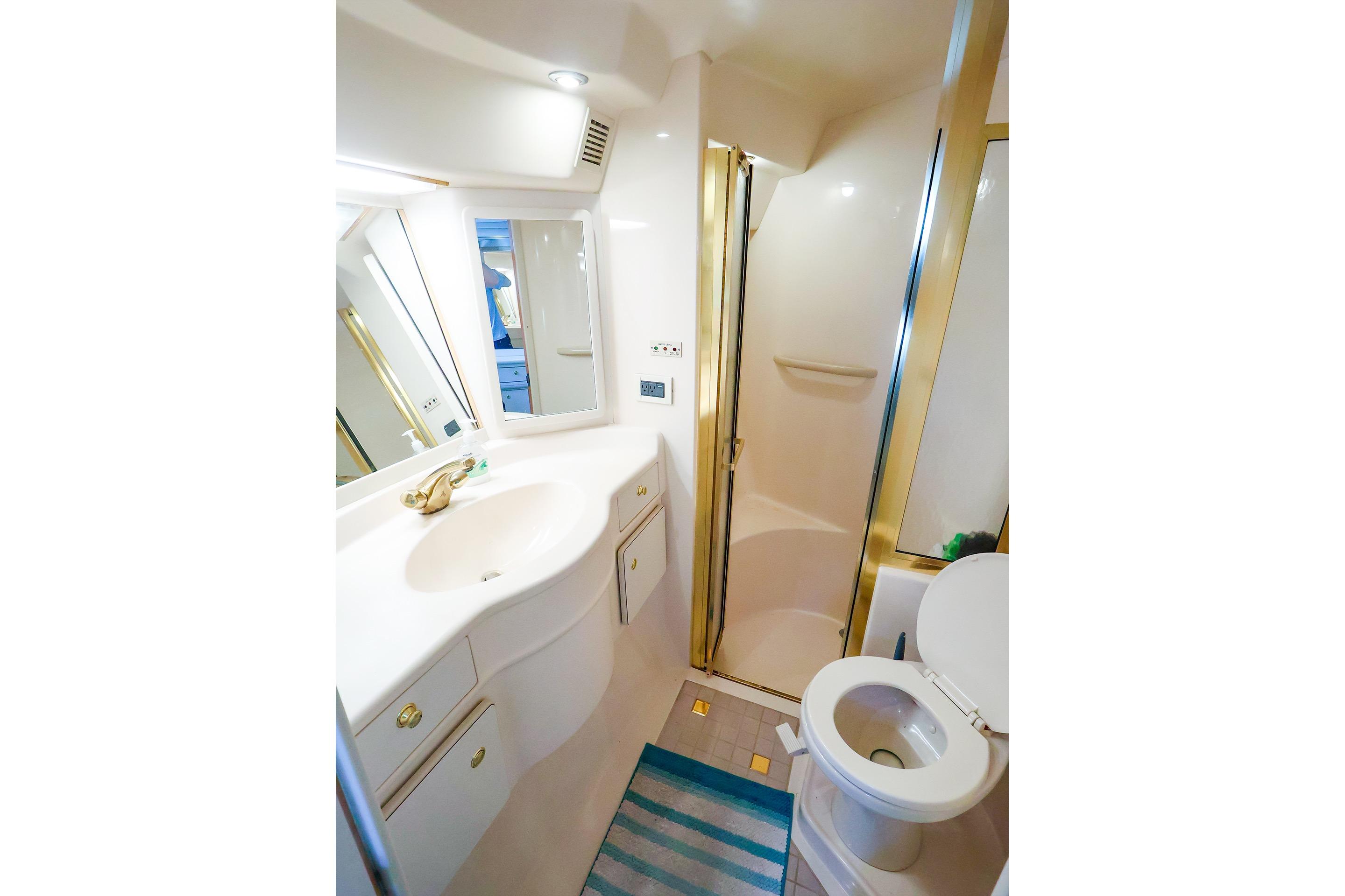 Luxurious bathroom in 1998 Sea Ray 500 Sundancer yacht, featuring shower and vanity.