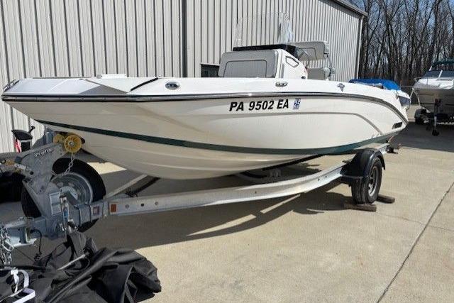 2022 Yamaha Boats 195 FSH Deluxe on trailer, parked outdoors near a building.