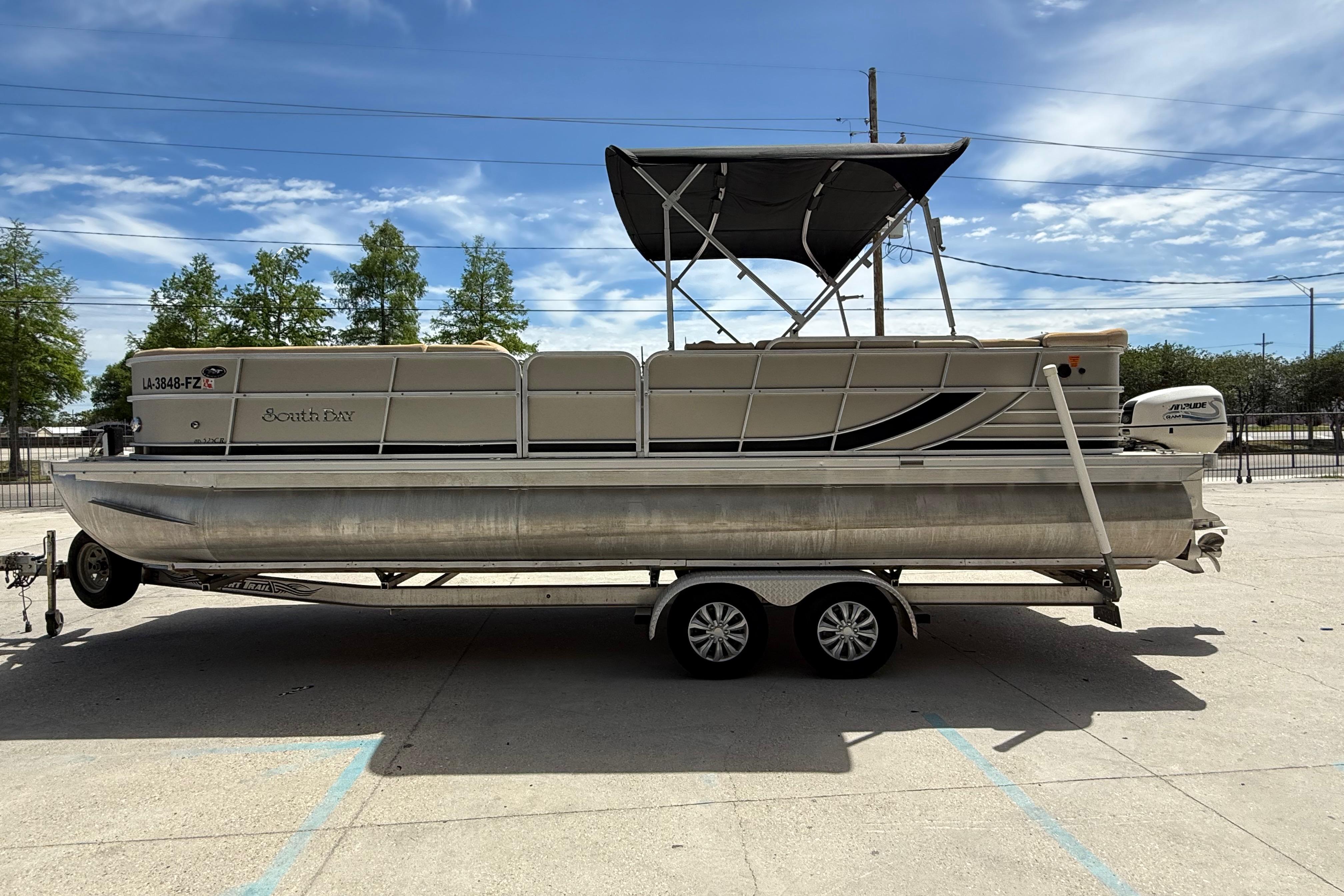 2012 South Bay 522 CR pontoon boat on trailer under clear sky.