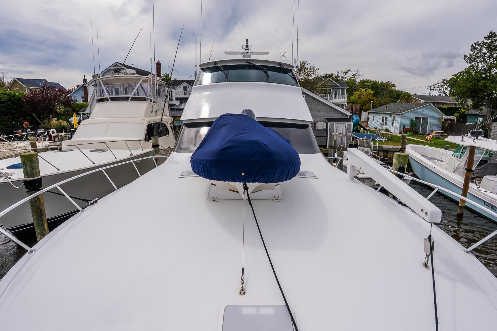 2002 Viking 61 Enclosed Bridge yacht docked, showcasing sleek design and spacious deck.