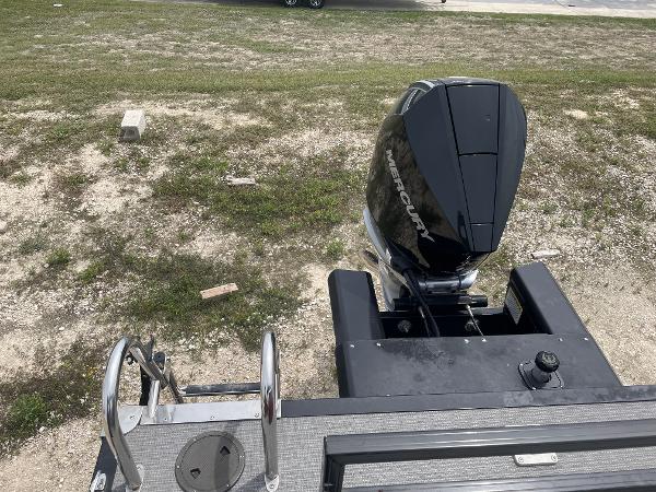 2023 Regency 250DL3 boat with Mercury outboard motor on grassy terrain.