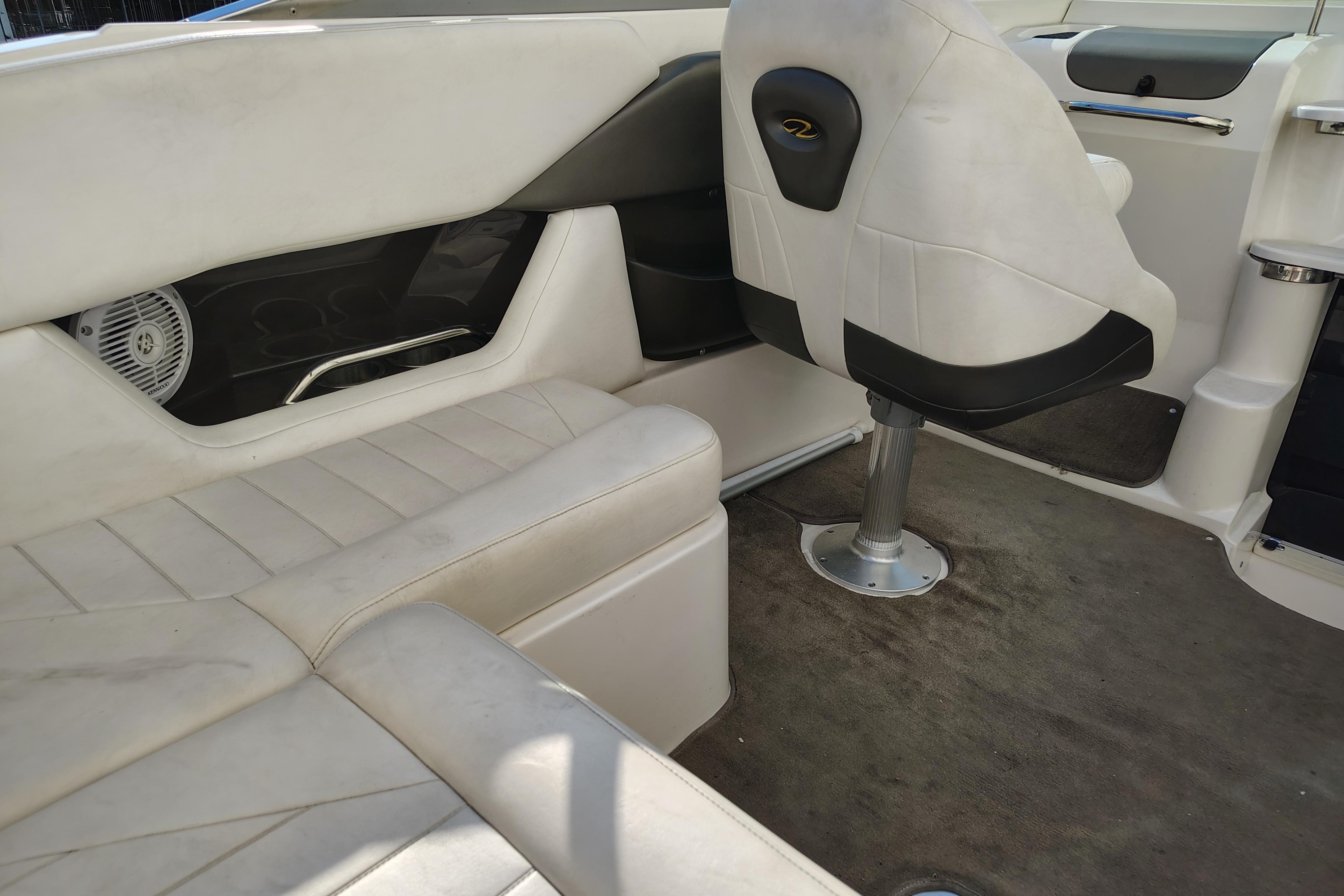 Interior of a 2006 Regal 2250 Cuddy boat with white seating and carpeted floor.