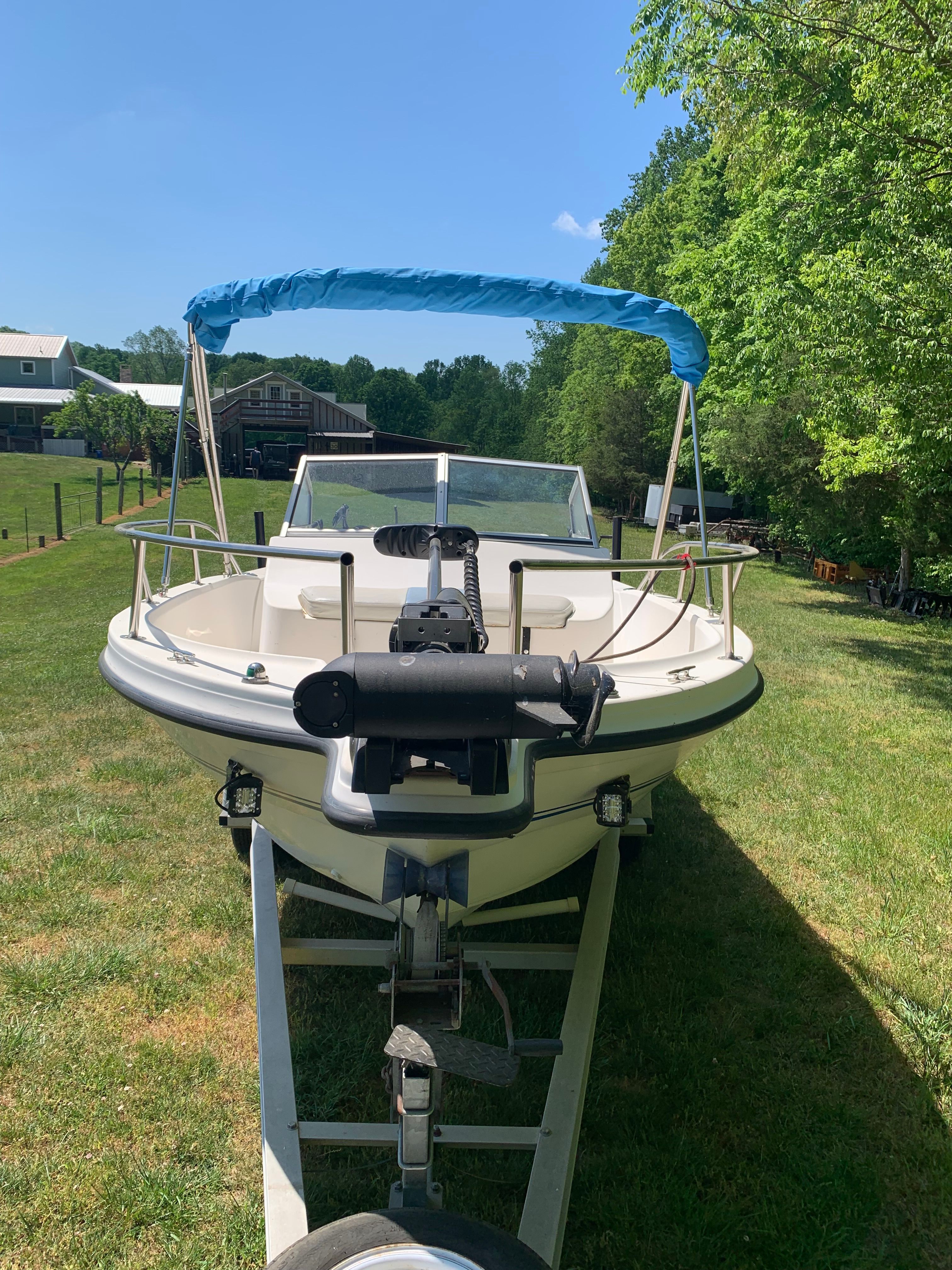 1998 Eurosport 221WA boat on a trailer in a grassy area.