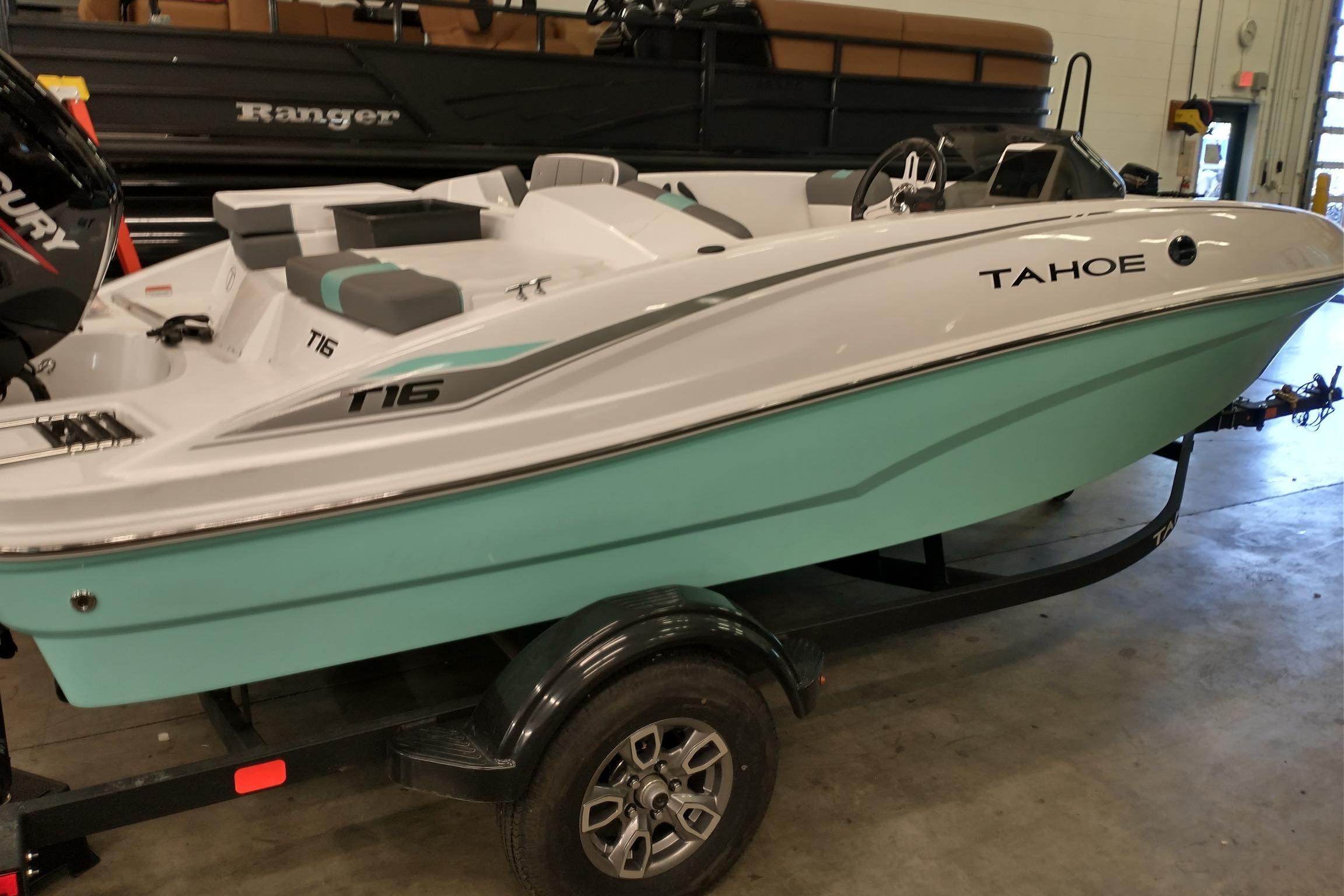2026 Tahoe T16 boat with sleek design on a trailer in a showroom.