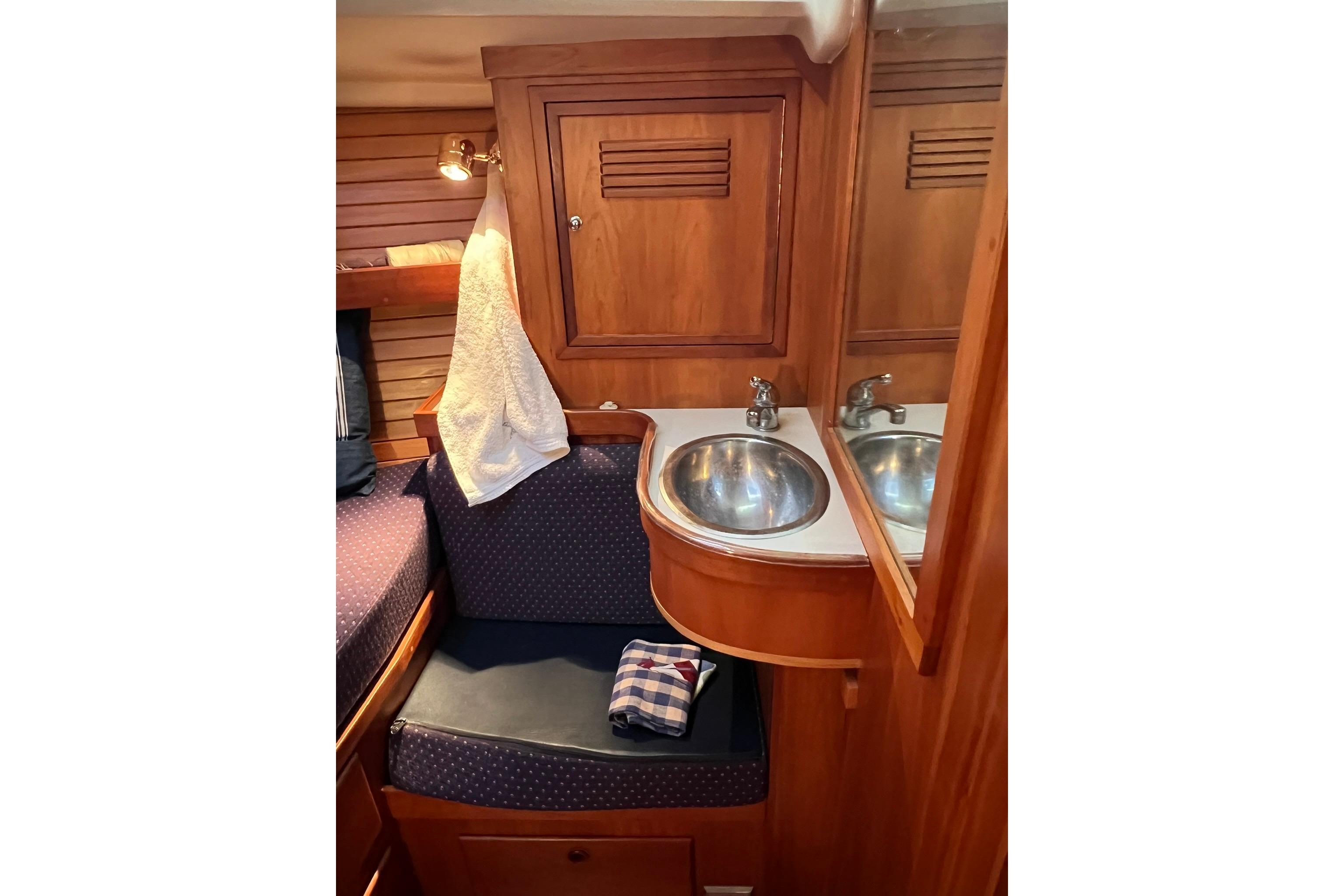 Cozy 1998 Sabre 362 yacht interior with wooden cabinetry and compact sink area.