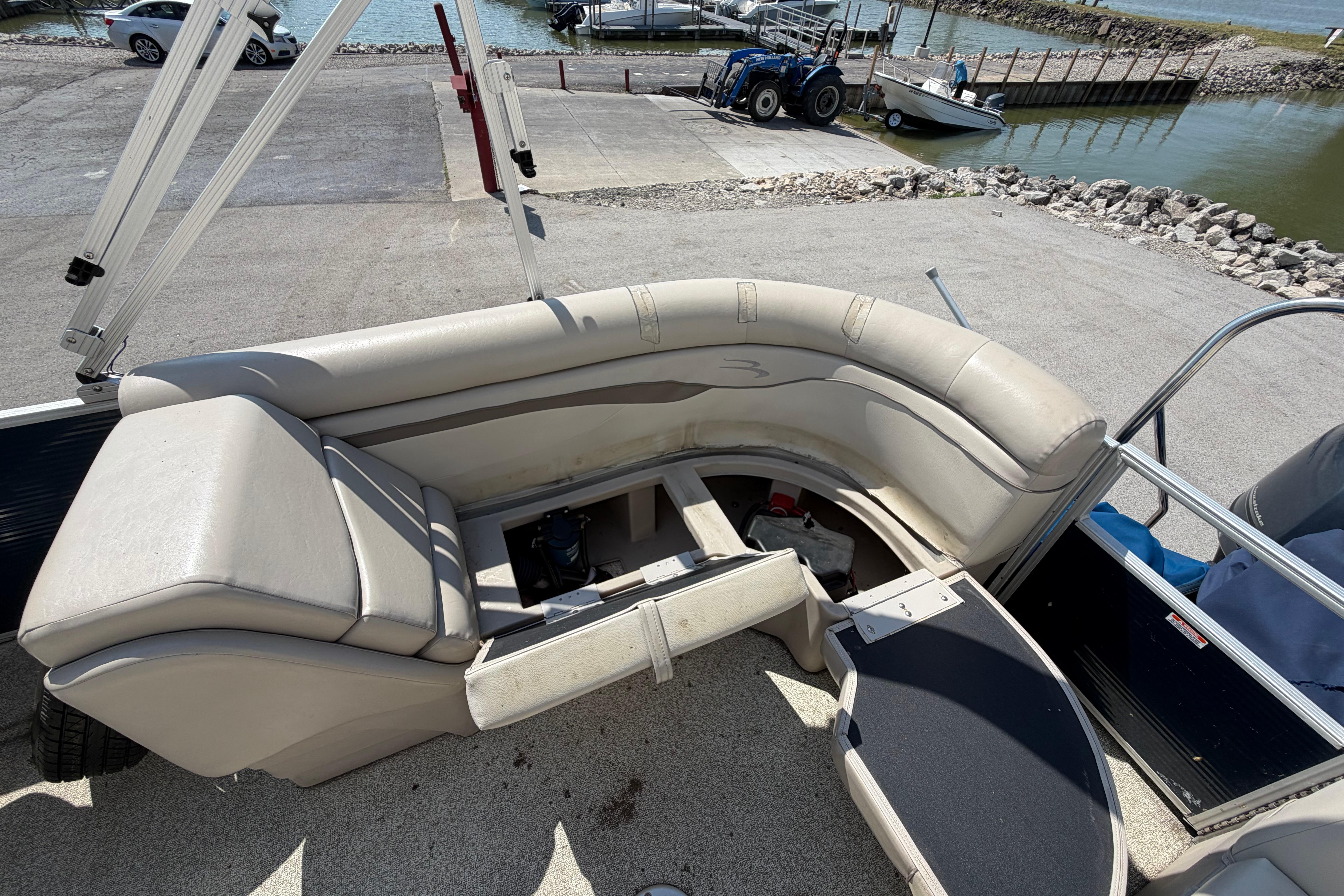 2017 Bennington 25 SSXAPG pontoon boat interior with beige seating and storage compartments.