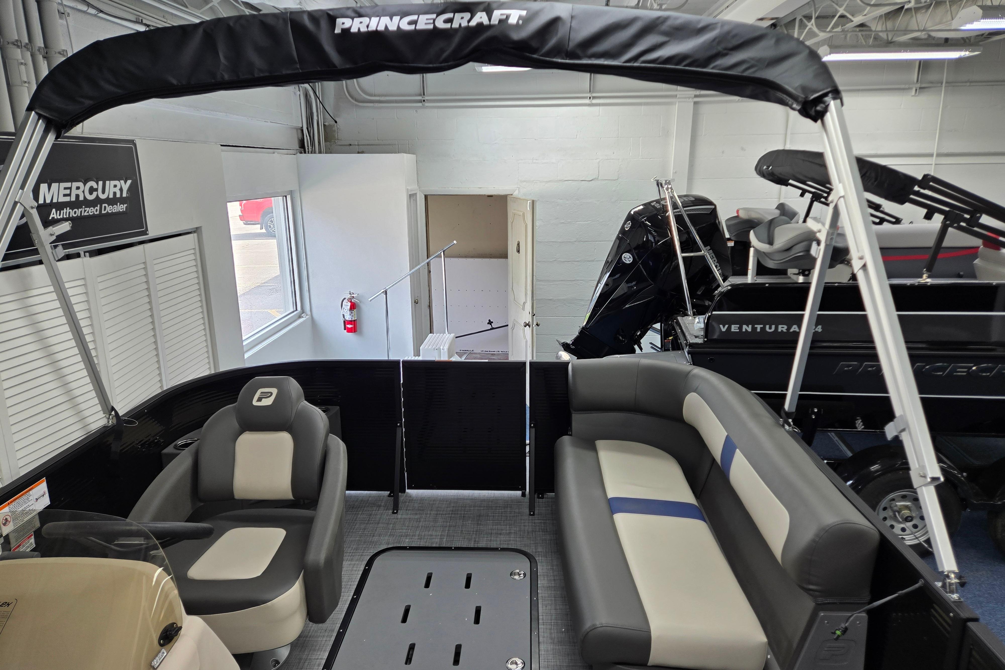 2026 Princecraft Brio 17 Electric boat interior with seating and canopy in showroom.