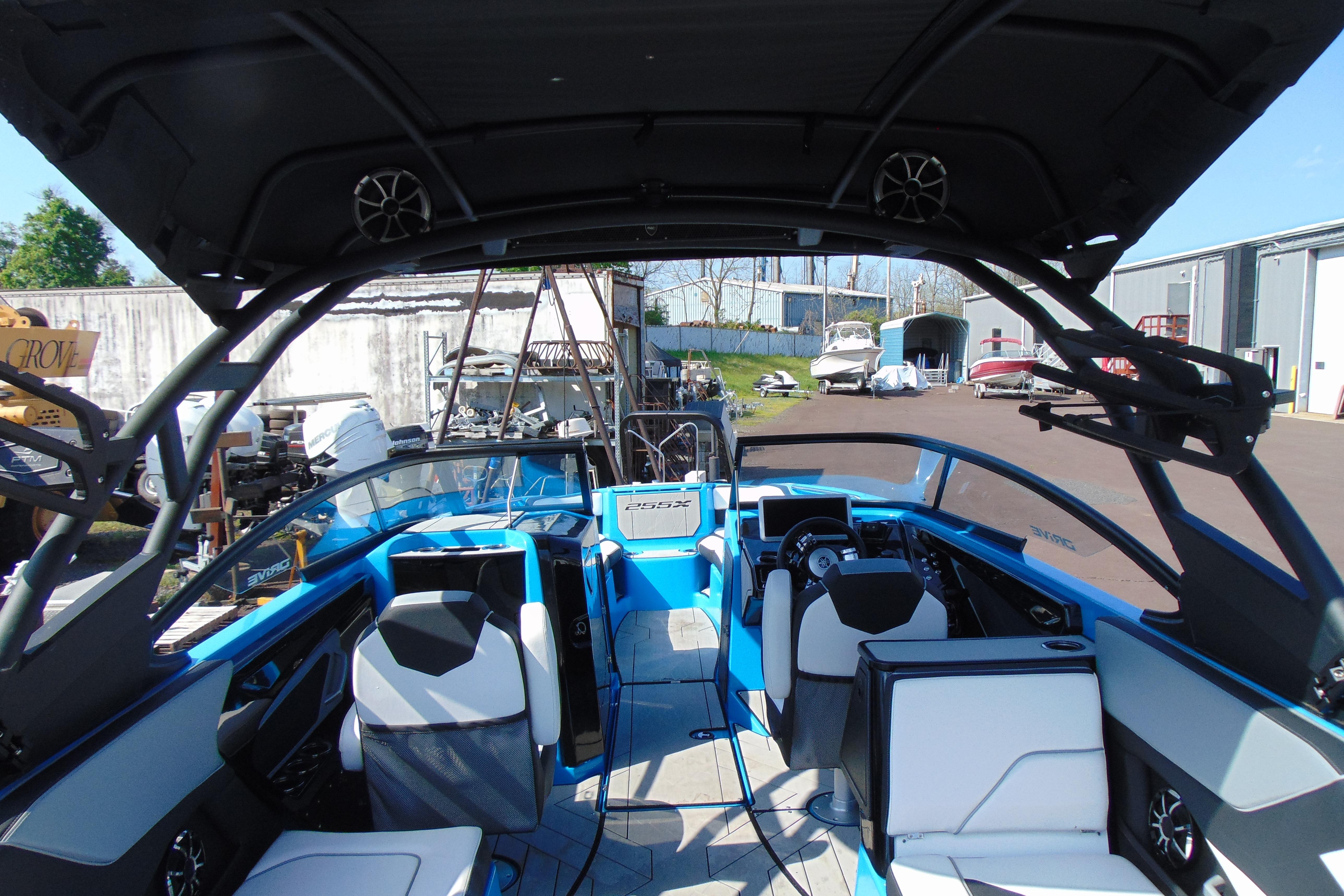 2022 Yamaha Boats 255XD interior with blue and white seating, modern dashboard, and open canopy.