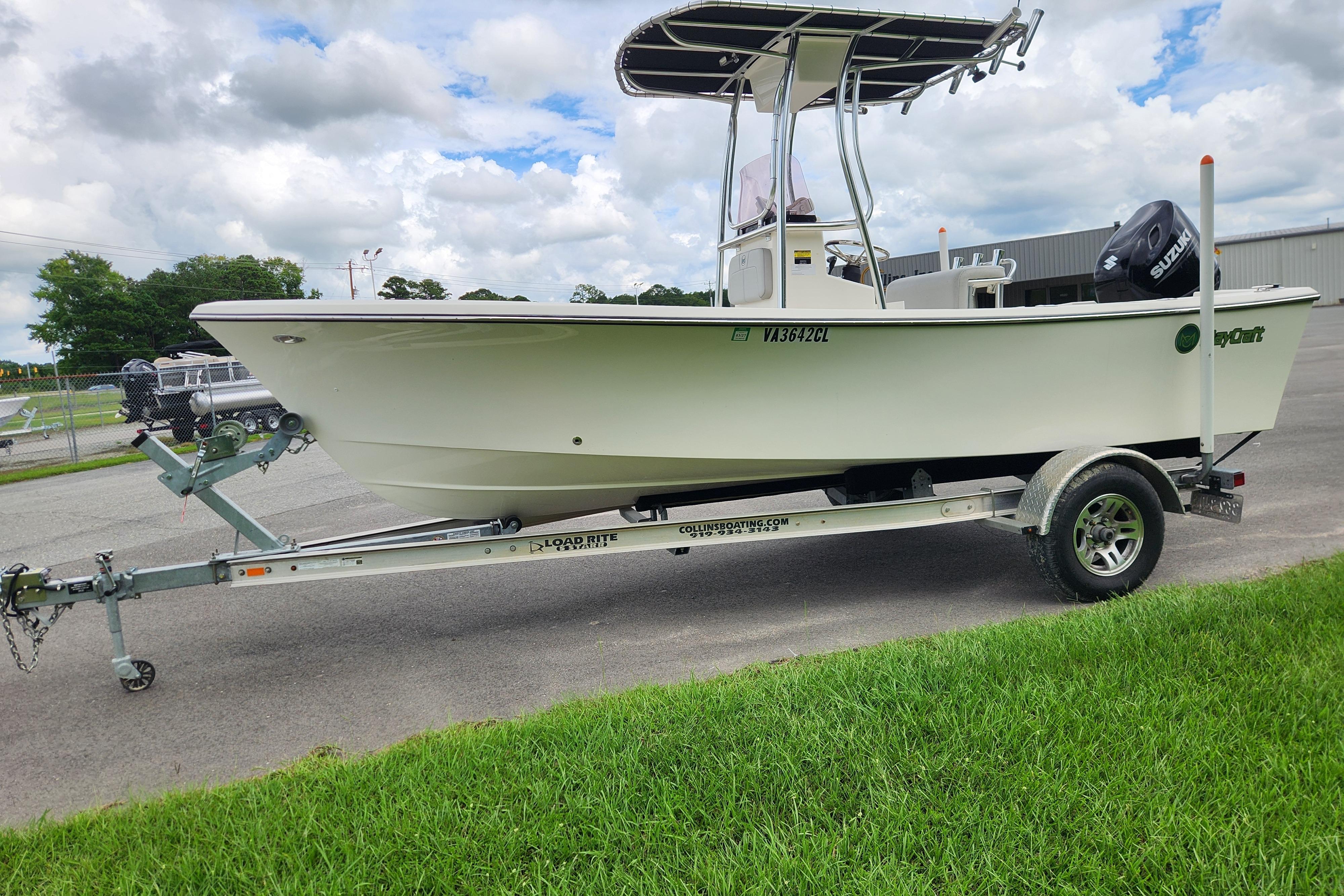 2023 May-Craft 1900CC boat on trailer, parked outdoors under cloudy sky.