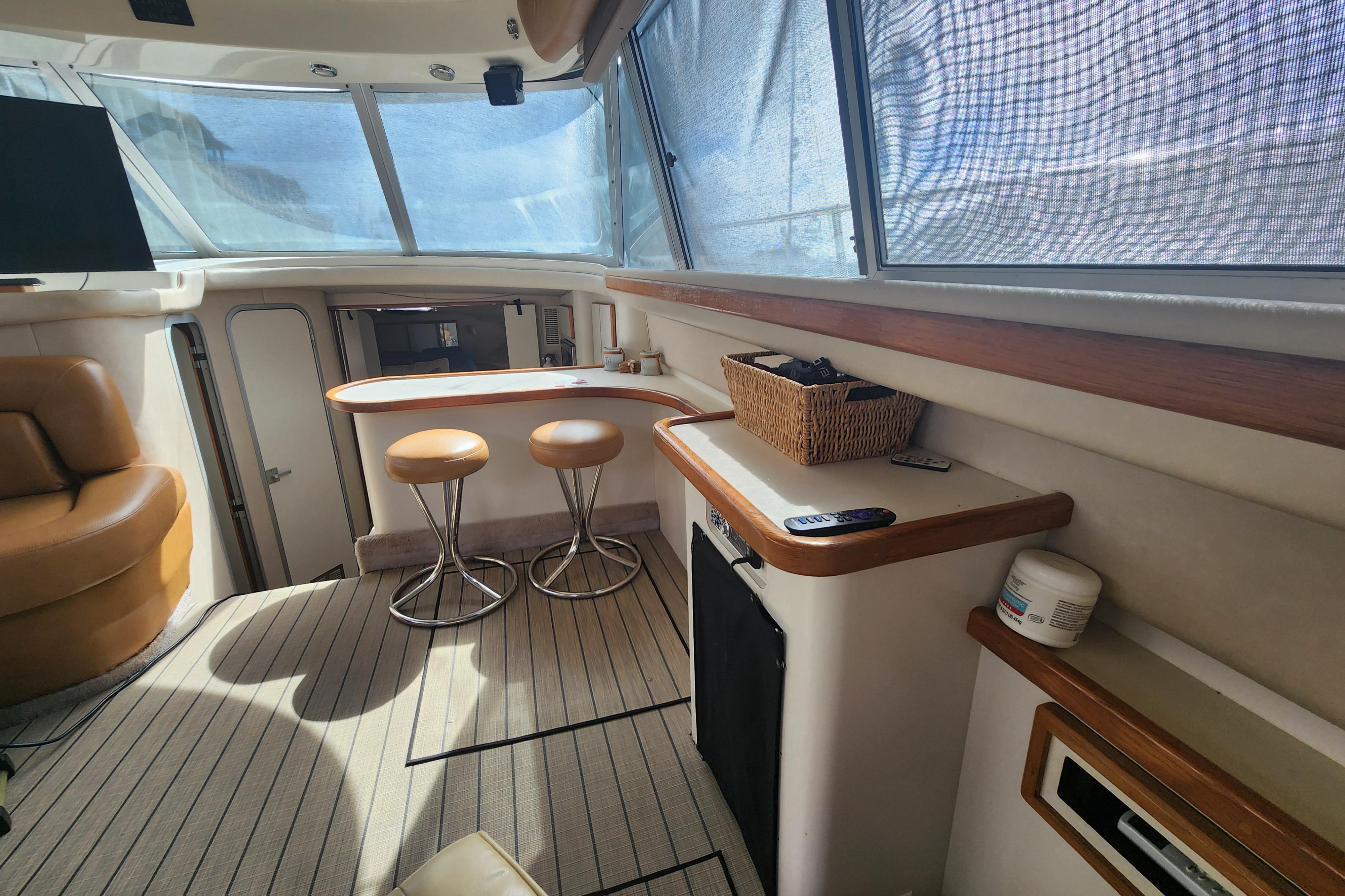 Interior of 1996 Sea Ray 370 Sedan Bridge with seating and bar area.