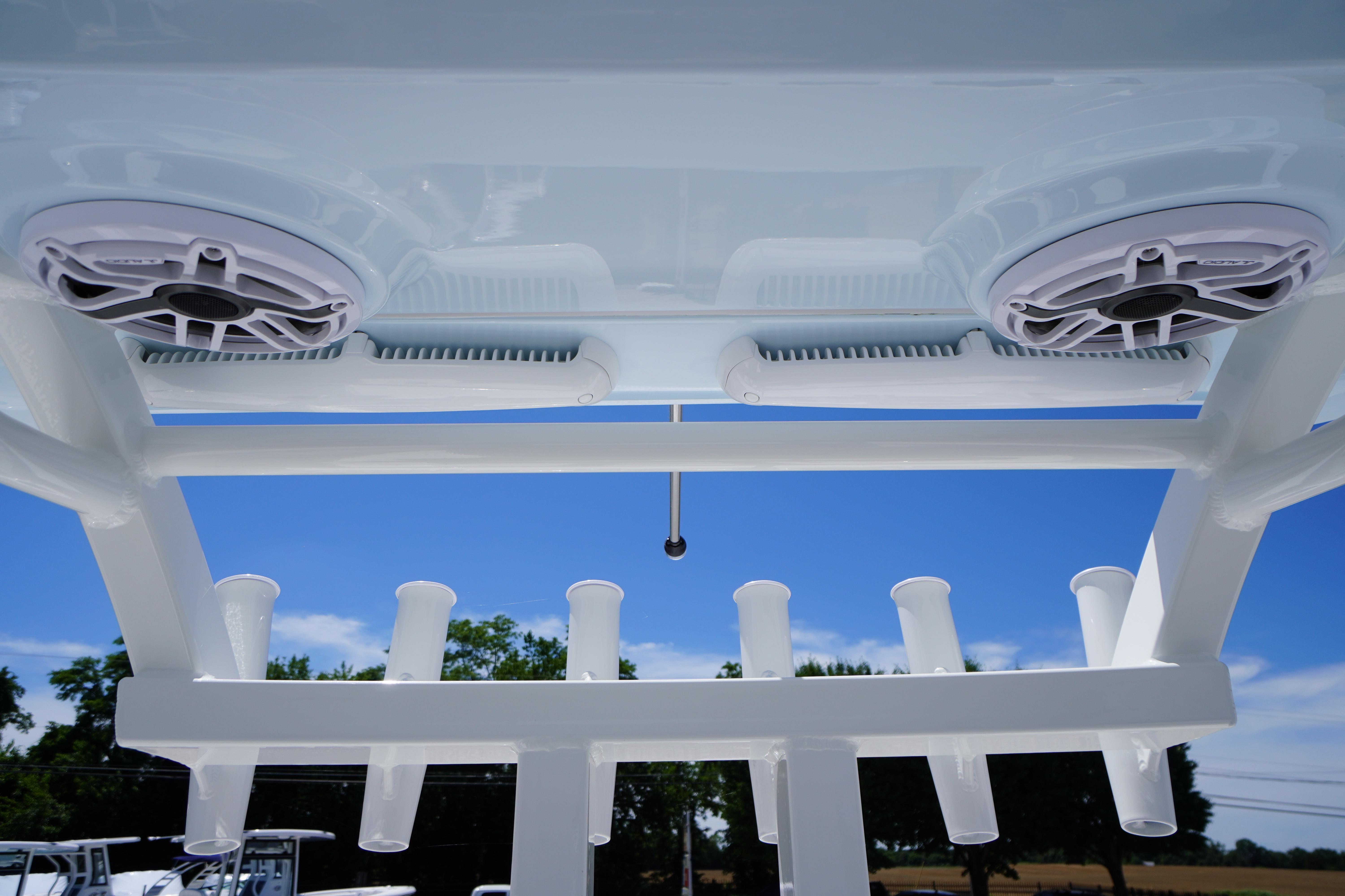 2026 Tidewater 302 CC Adventure boat speakers and rod holders under clear blue sky.
