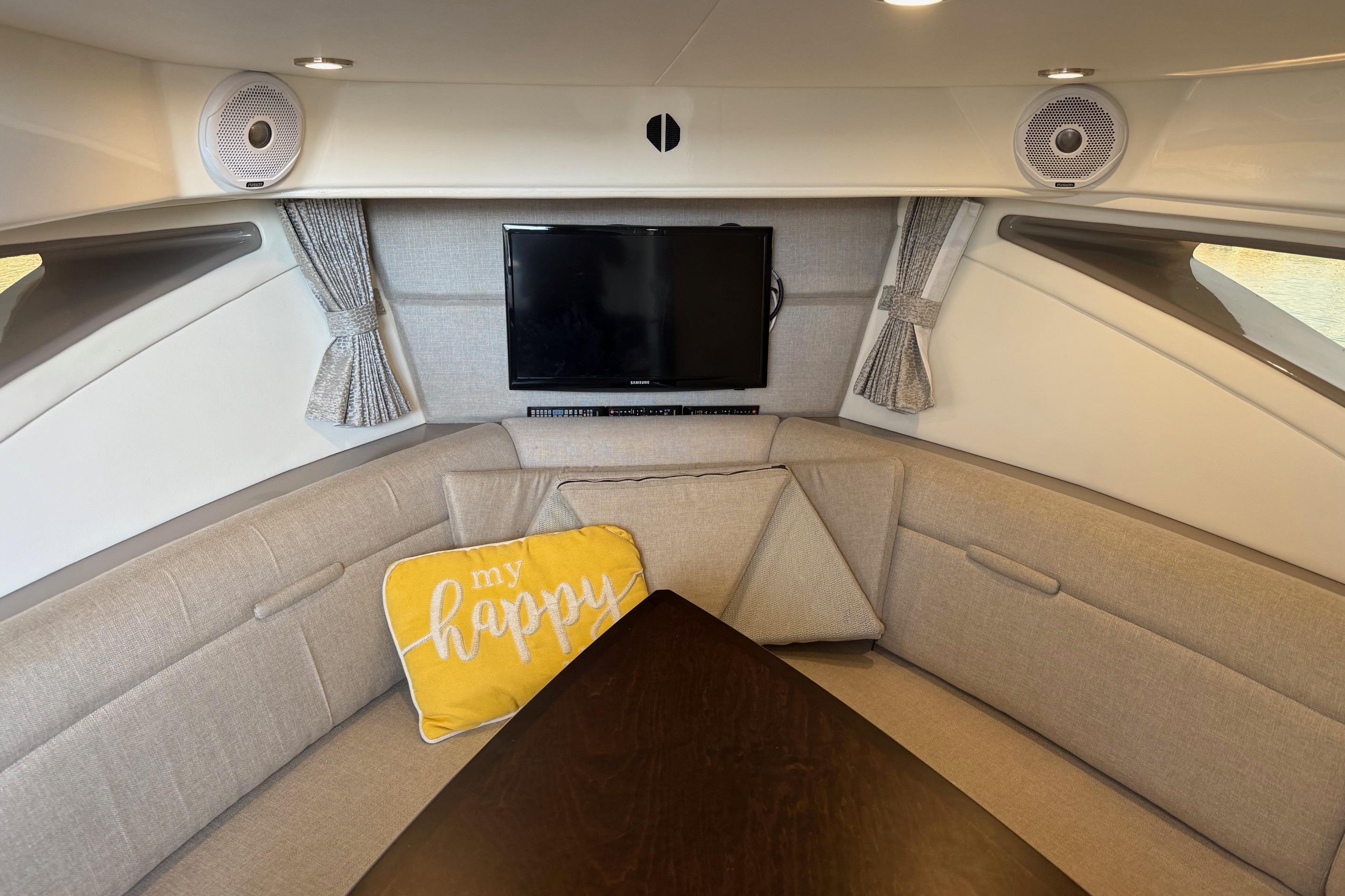 Interior of 2019 Sea Ray Sundancer 320 with cozy seating and TV.