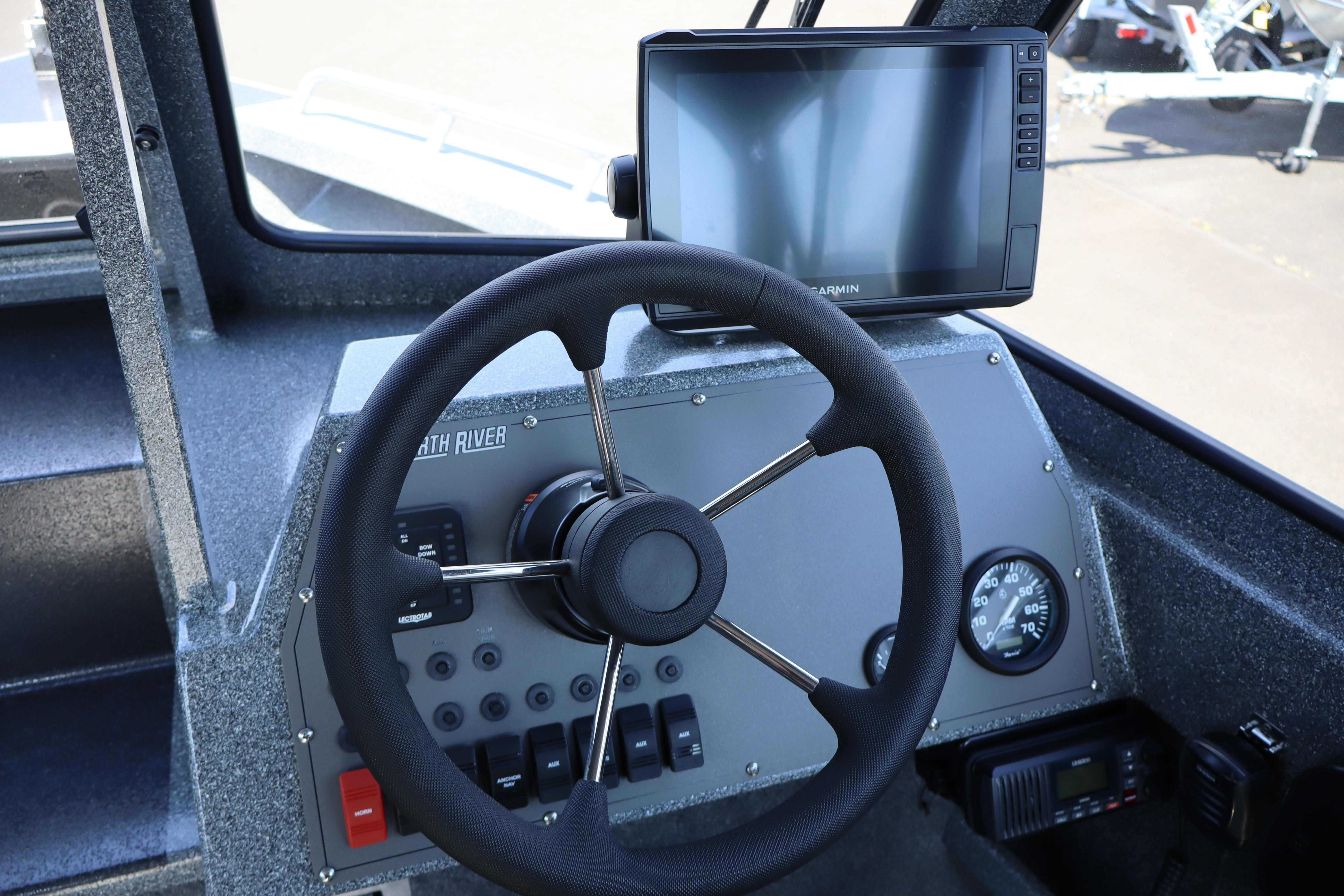 2025 NorthRiver SEAHAWK boat dashboard with steering wheel and navigation display.