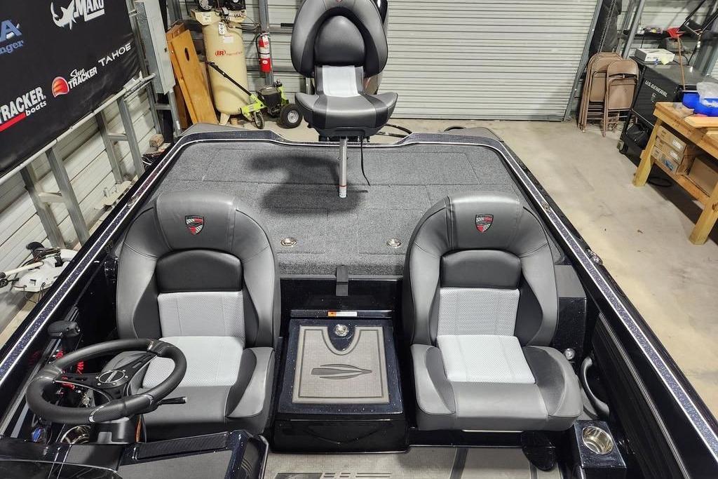2026 Triton 20XP Patriot boat interior with dual seats and steering wheel in a garage setting.