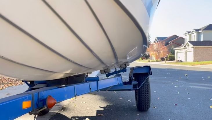 1962 Larsen 13 boat on blue trailer in residential area.