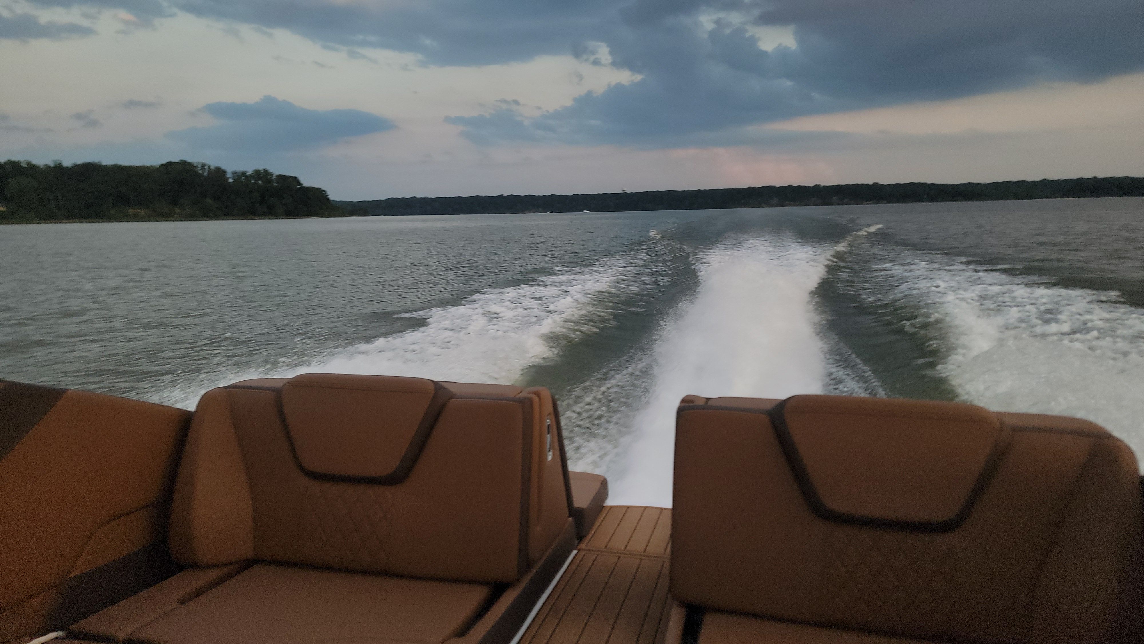 Yamaha Boats 252SE 2024 cruising on a lake at sunset.
